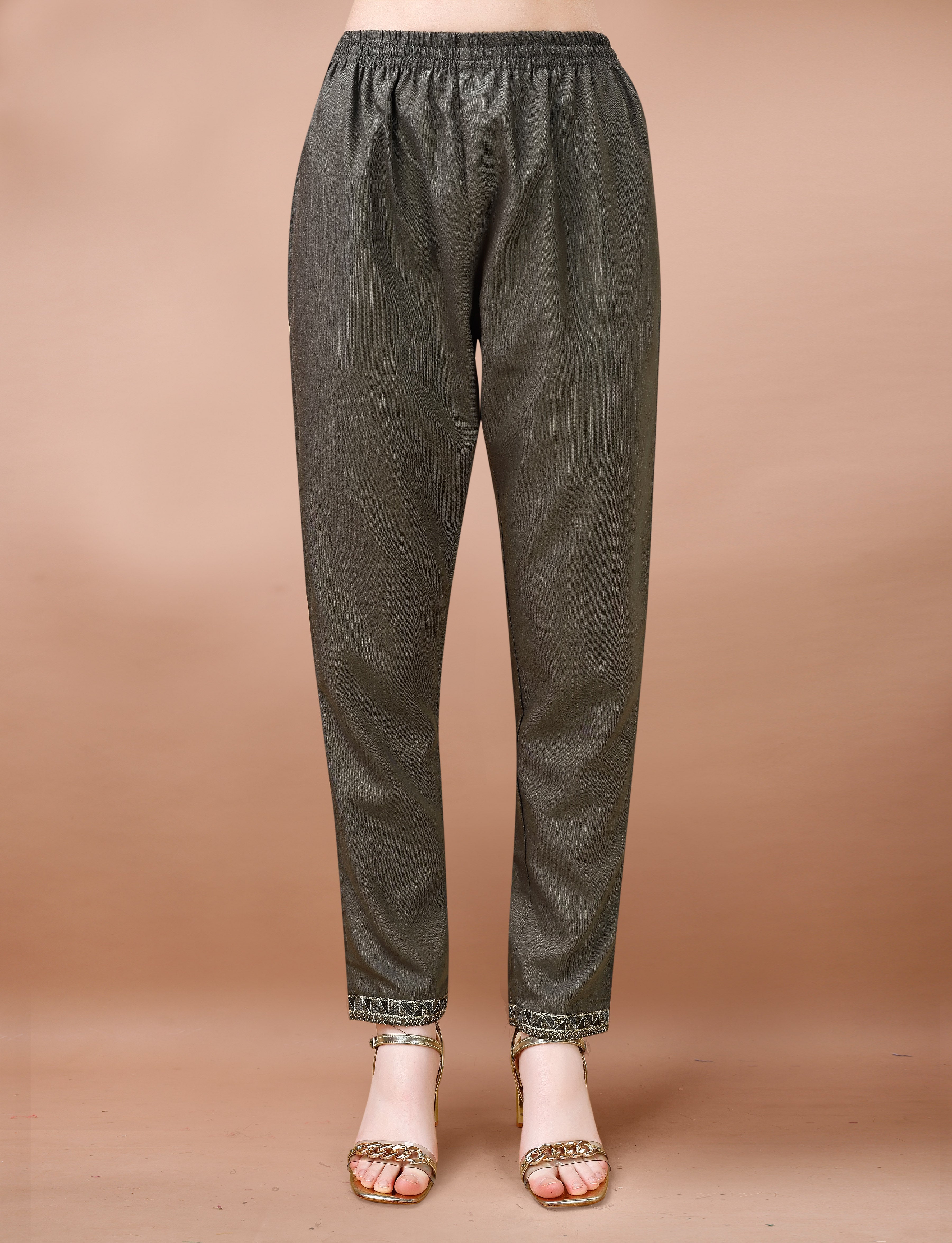 Mannequin displaying charcoal grey cotton blend trousers with intricate geometric embroidery on the cuffs.