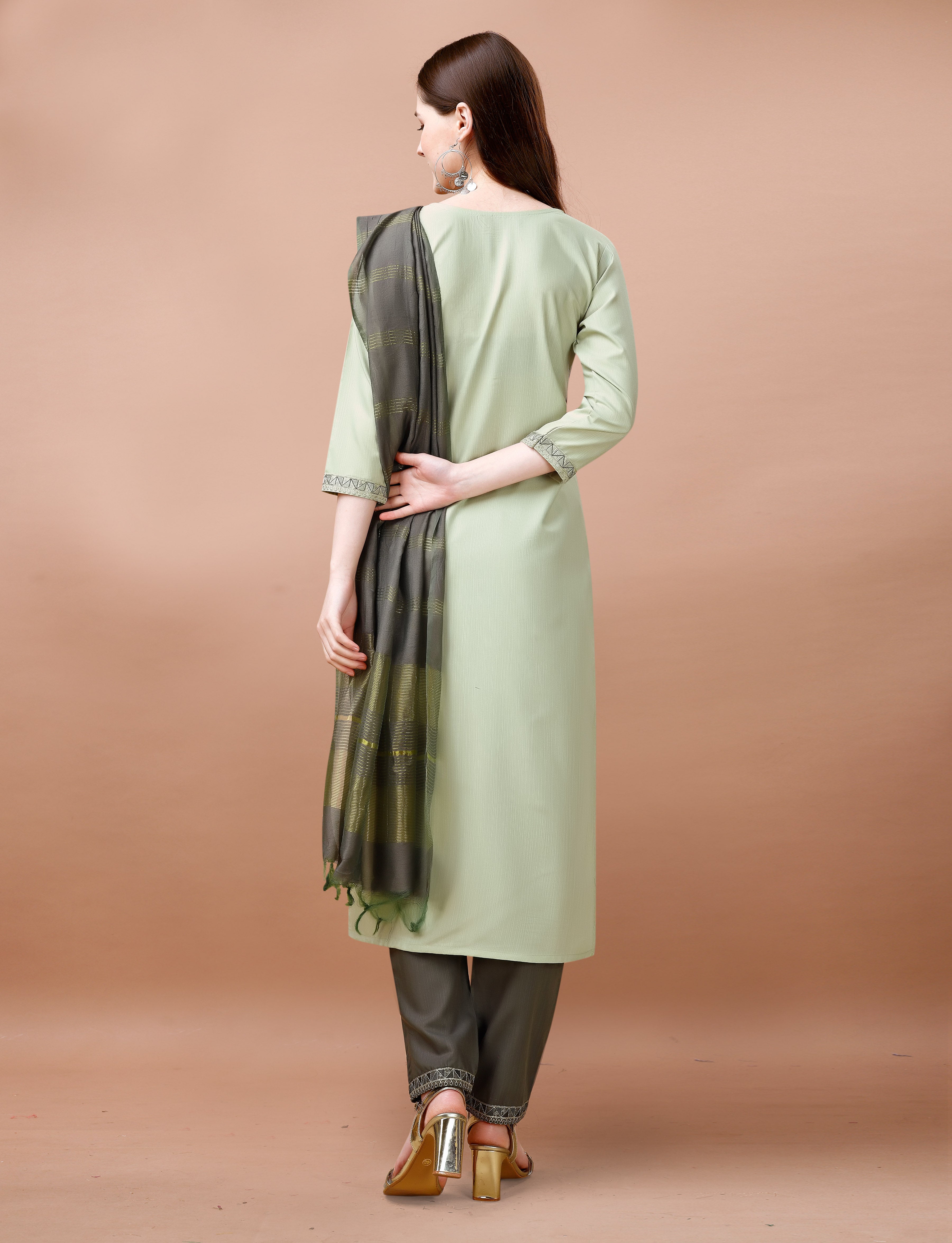 Rear view of a woman showcasing a sage green embroidered kurta set with a charcoal grey Chanderi dupatta draped over her shoulder.