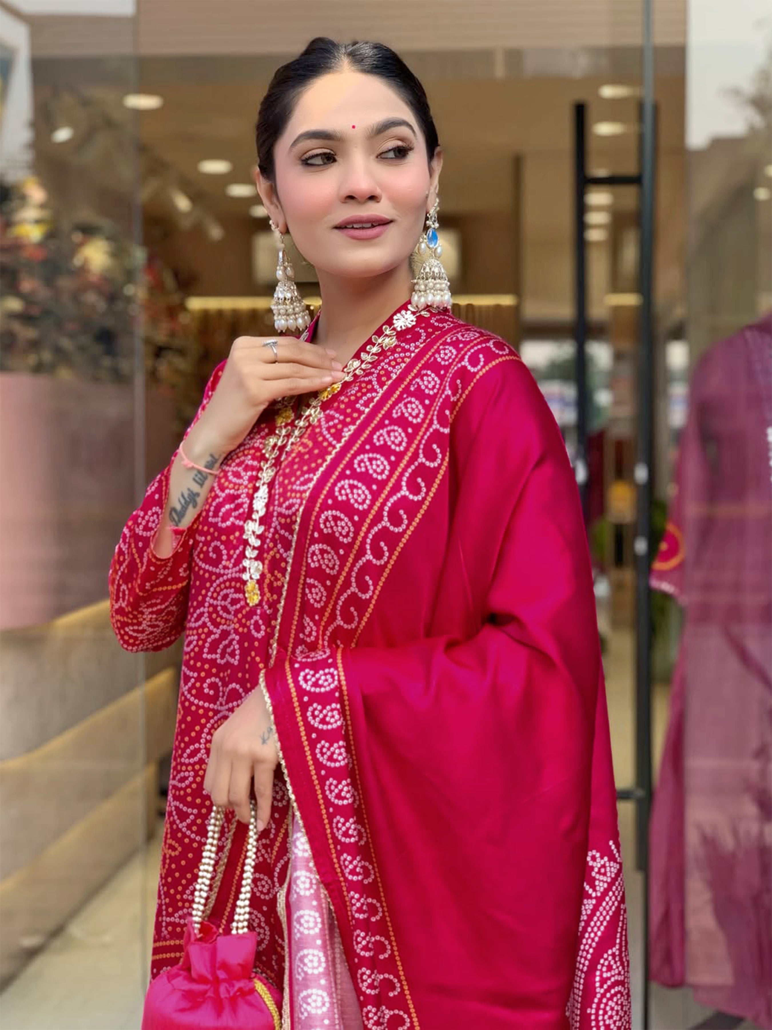 Side profile of a woman gracefully posing in a vibrant magenta Viscose Silk Kurti set, showcasing the flowing Chanderi cotton dupatta and matching pants.