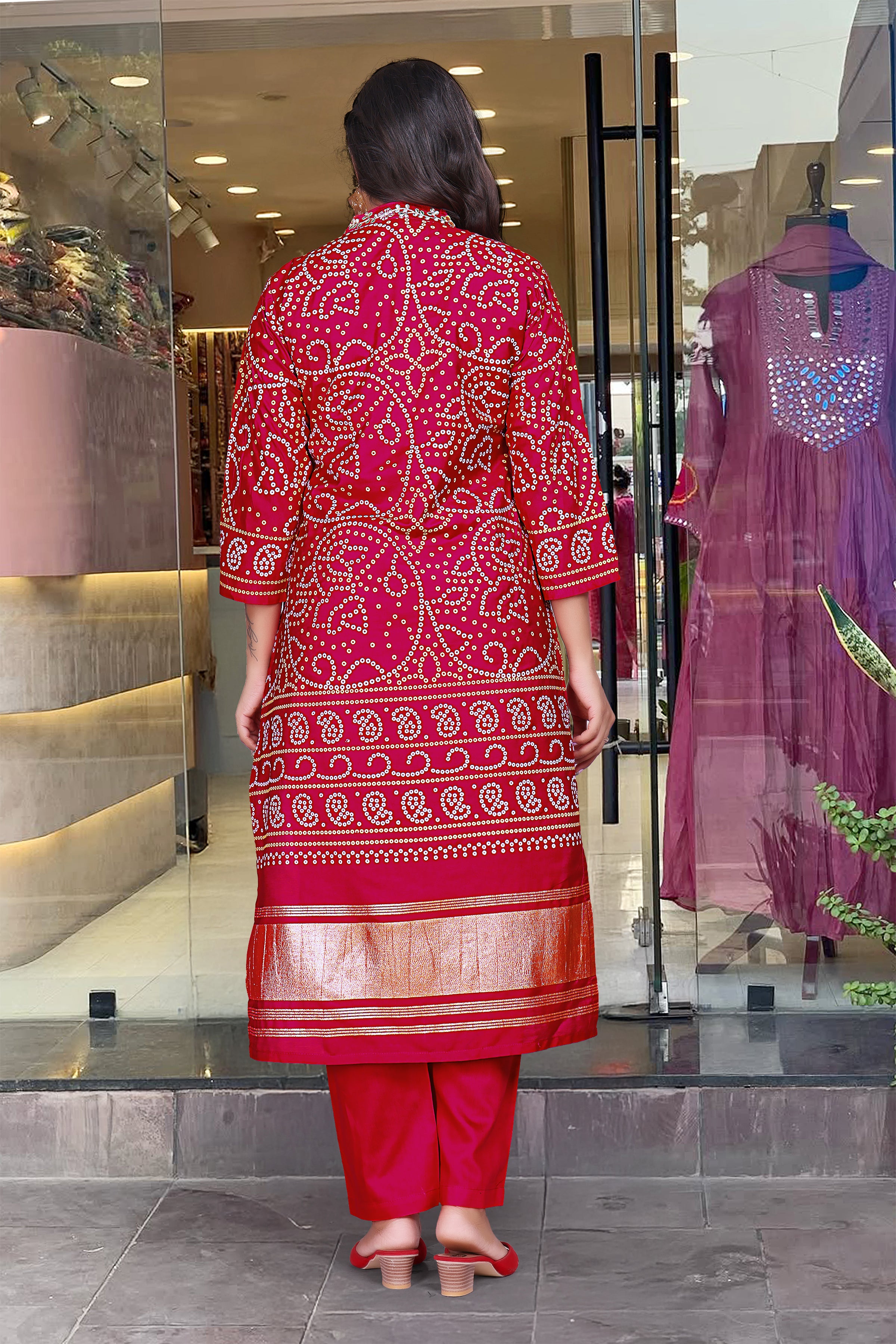 Rear view of a woman in the magenta Viscose Silk Kurti, highlighting the back hand-printed design and the golden border details on the hem, paired with matching cotton pants.