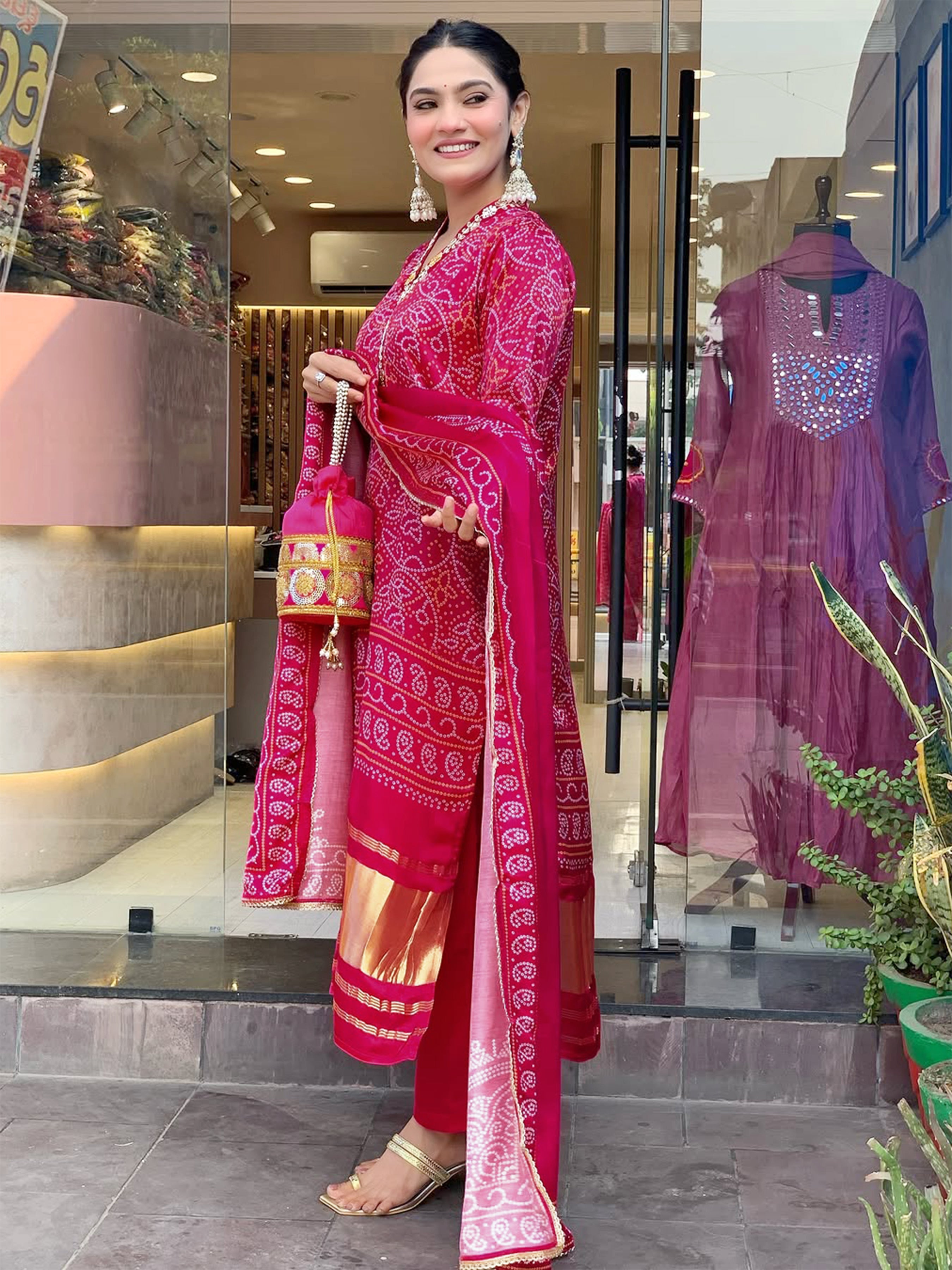 Side view of a woman in the complete magenta NAVYA Kurti set, displaying the comfortable fit of the pants, the patterned kurti, and the gracefully draped dupatta.