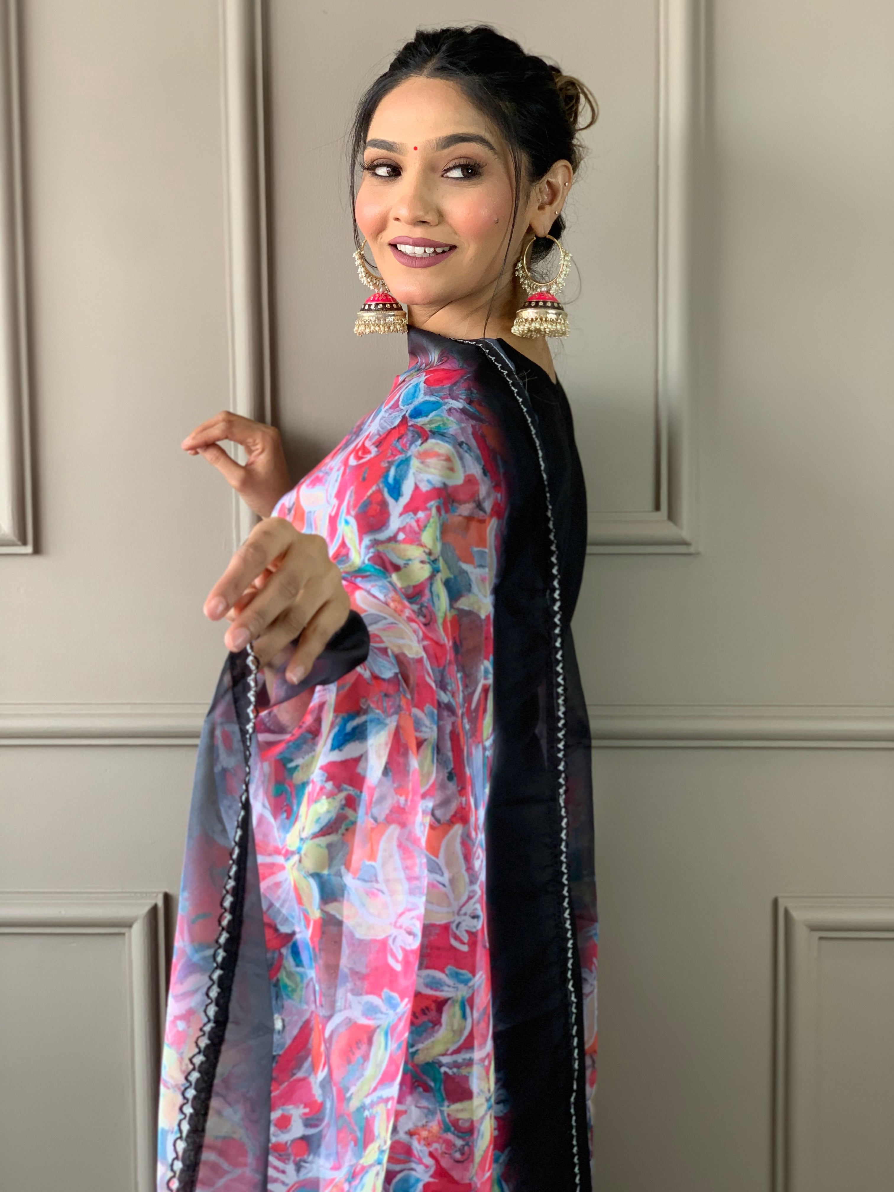 Close-up side profile of woman smiling, showcasing TRENDBUY black kurta neckline embroidery and the colorful printed organza dupatta.