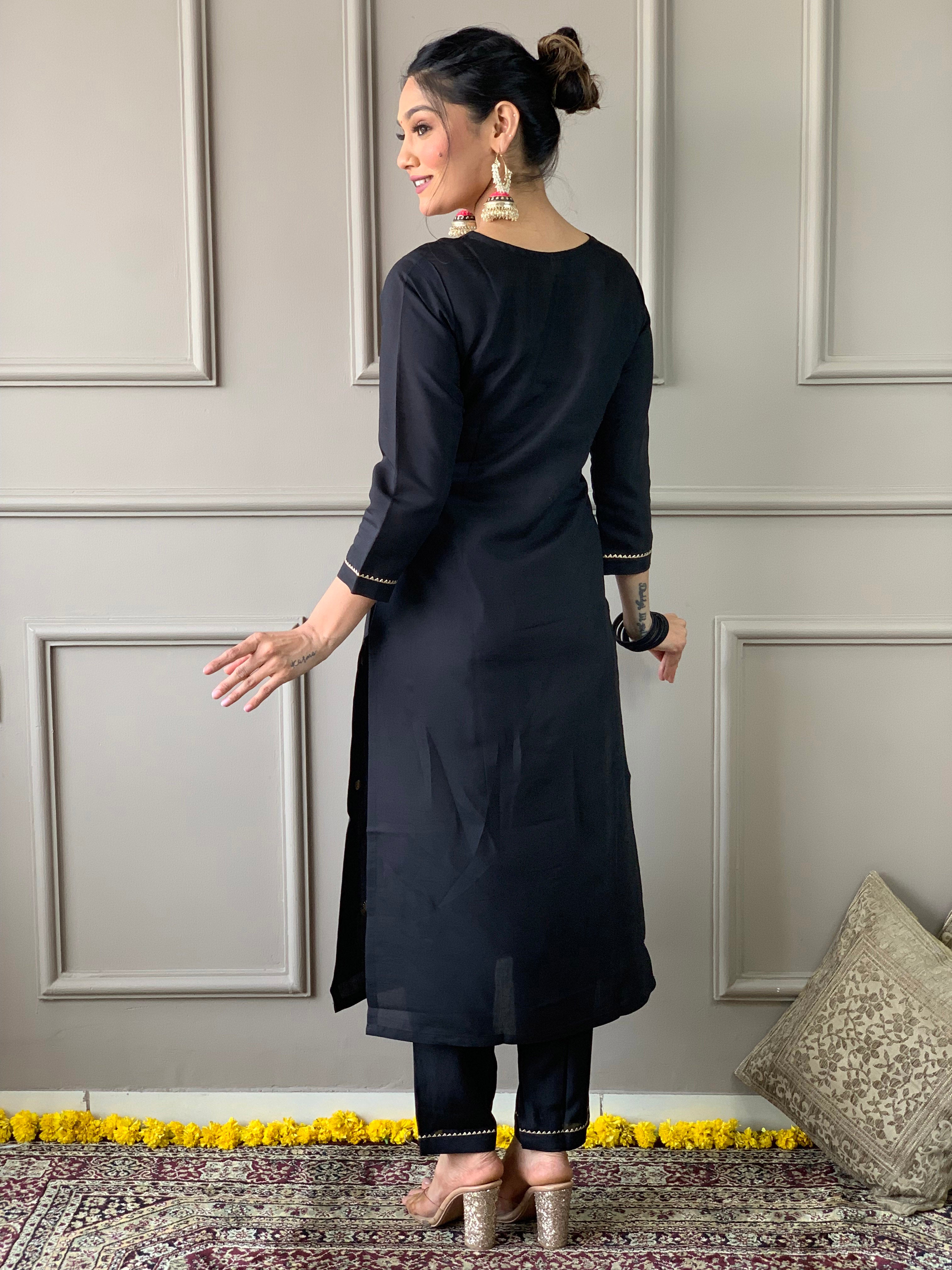 Back view of a woman in TRENDBUY black rayon slub kurta and pants, showing the elegant straight cut and simple design.