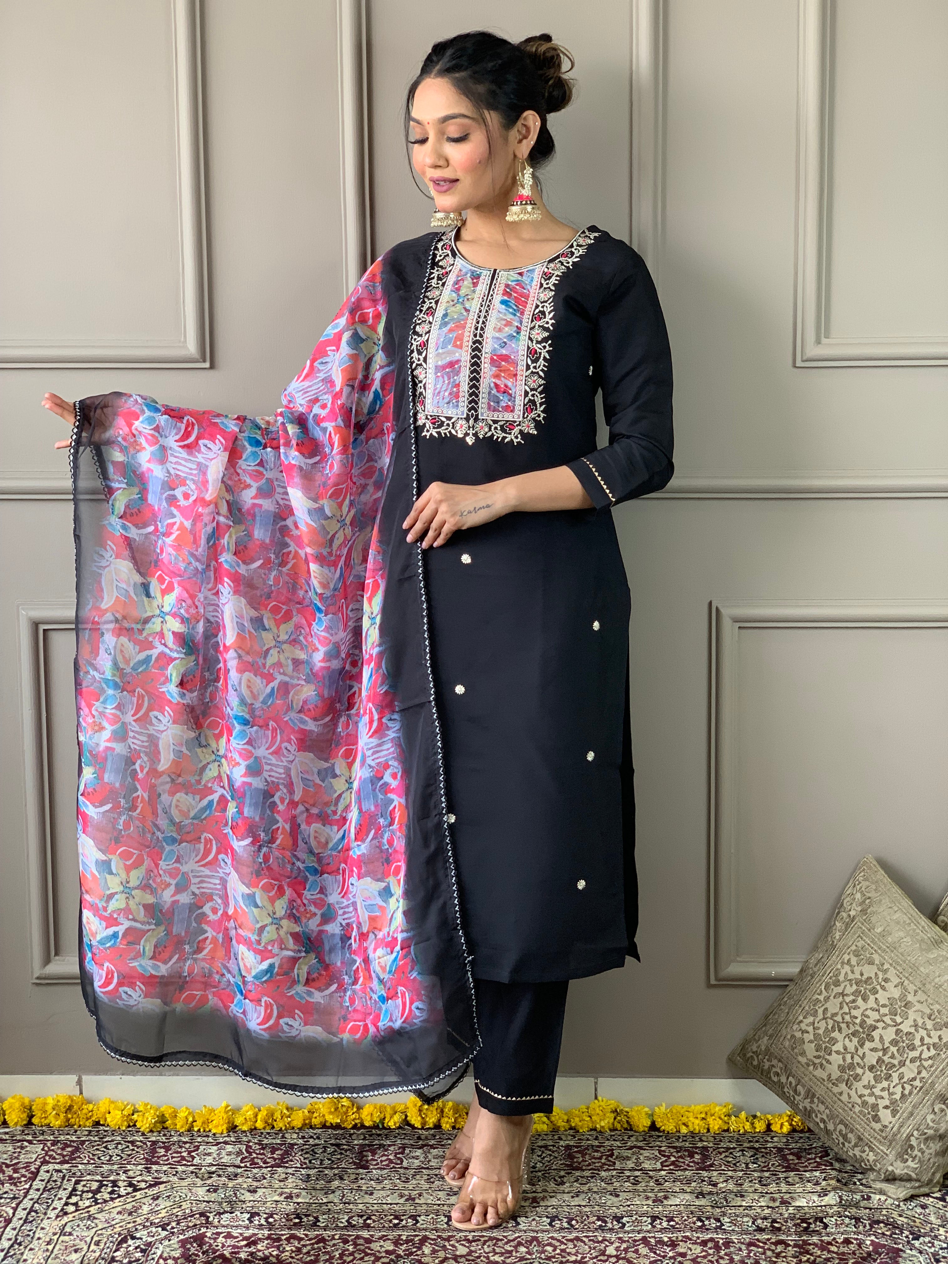 Full length shot of a woman confidently standing in TRENDBUY black rayon slub kurta set, gently holding the printed organza dupatta.