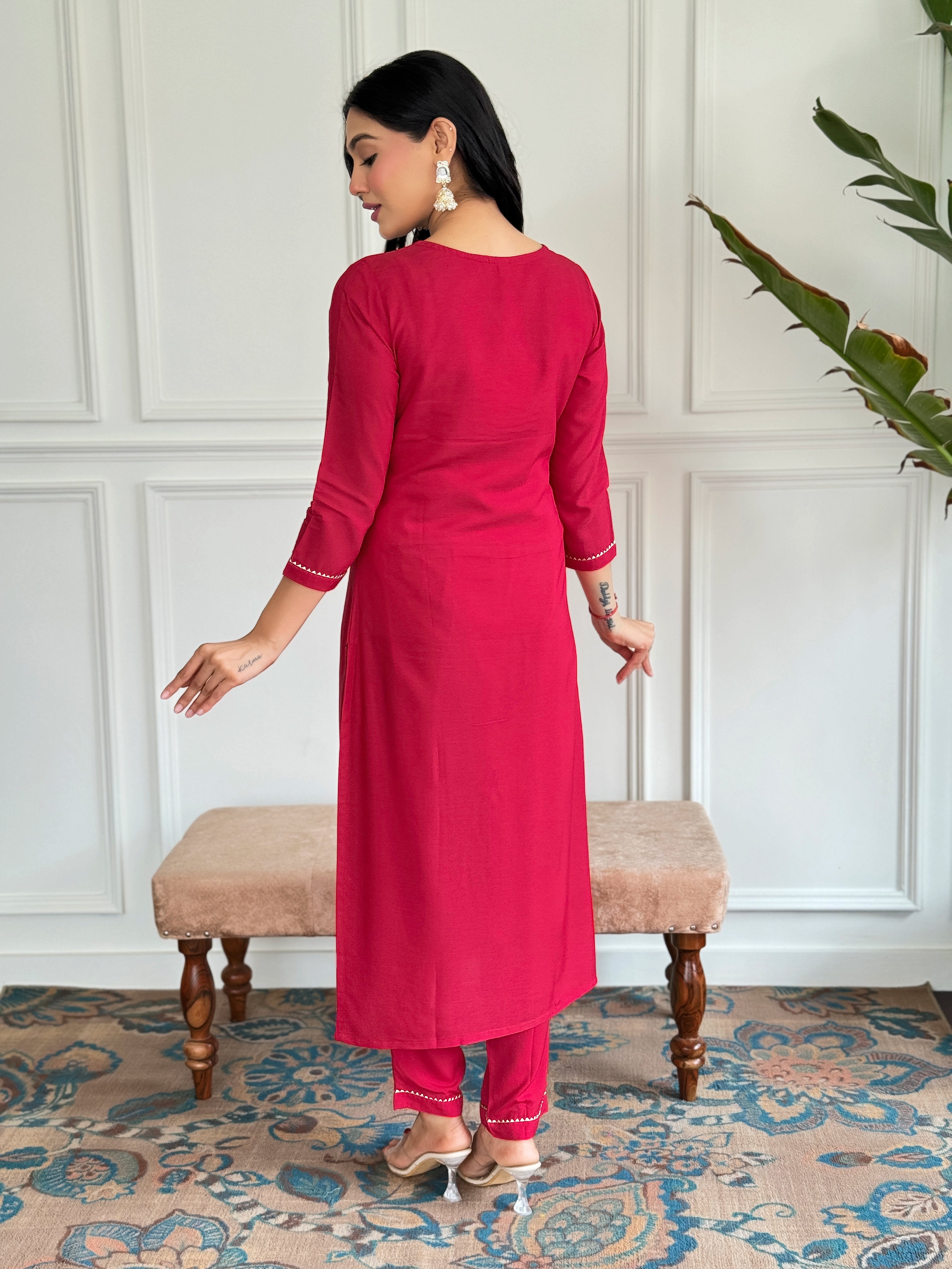Back view of the model in the red rayon straight kurta and pant set, showcasing the clean lines and simple elegance of the outfit.