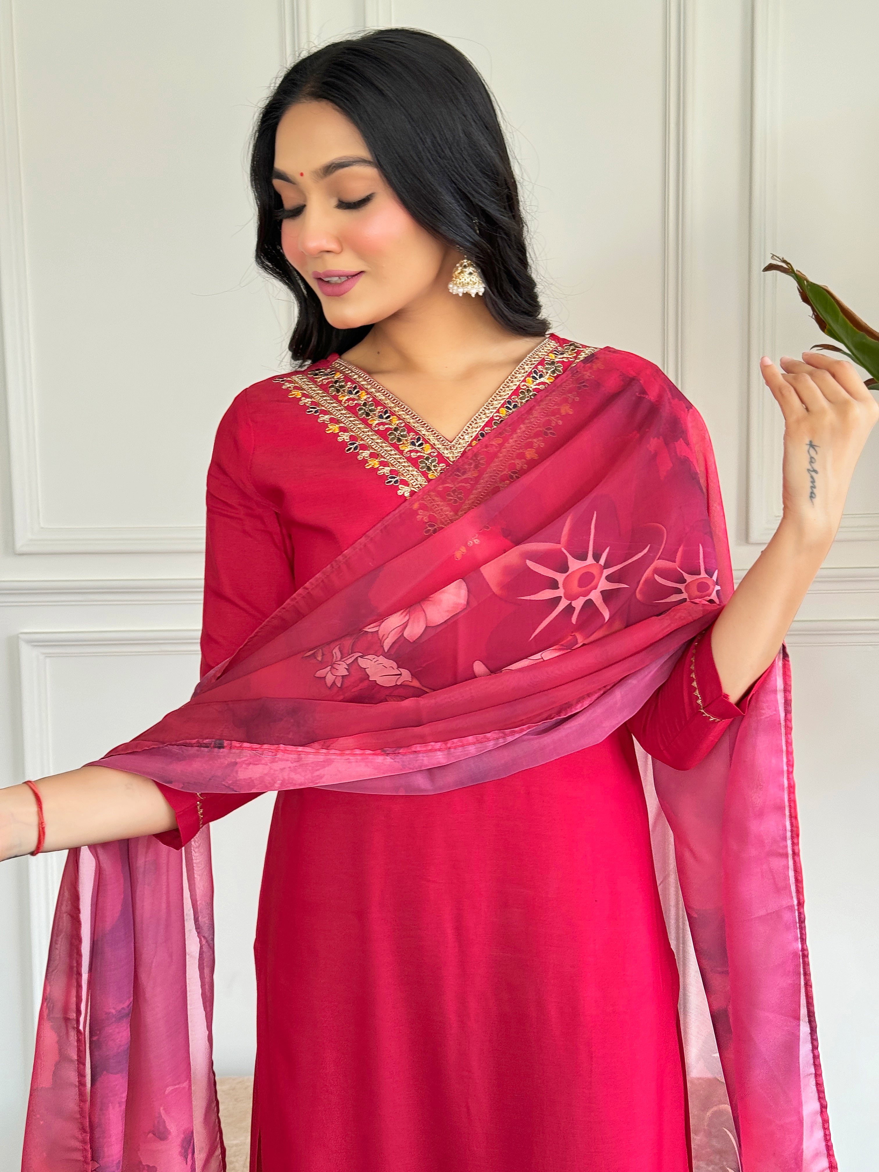 Close-up of the model's upper body, featuring the embroidered V-neck kurta and the beautiful floral print of the red silk dupatta.