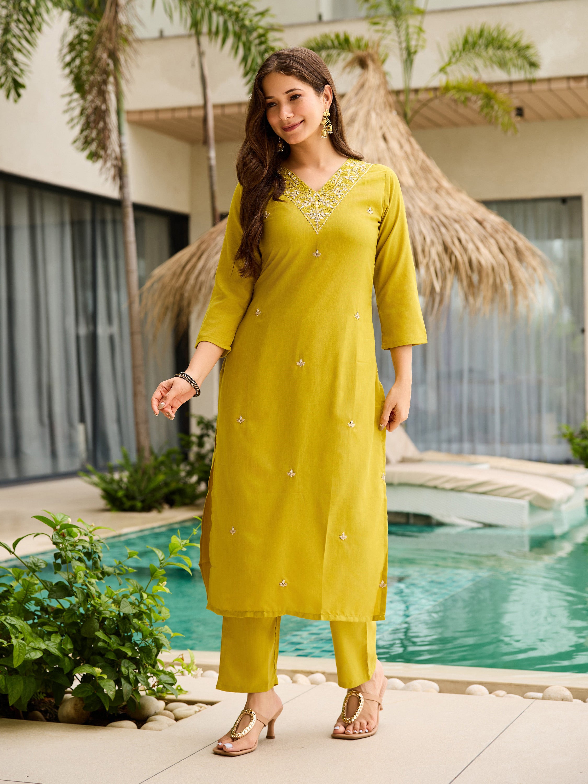 Woman showcasing the full lemon yellow kurti set with elegant ¾ sleeves, standing confidently by the pool.