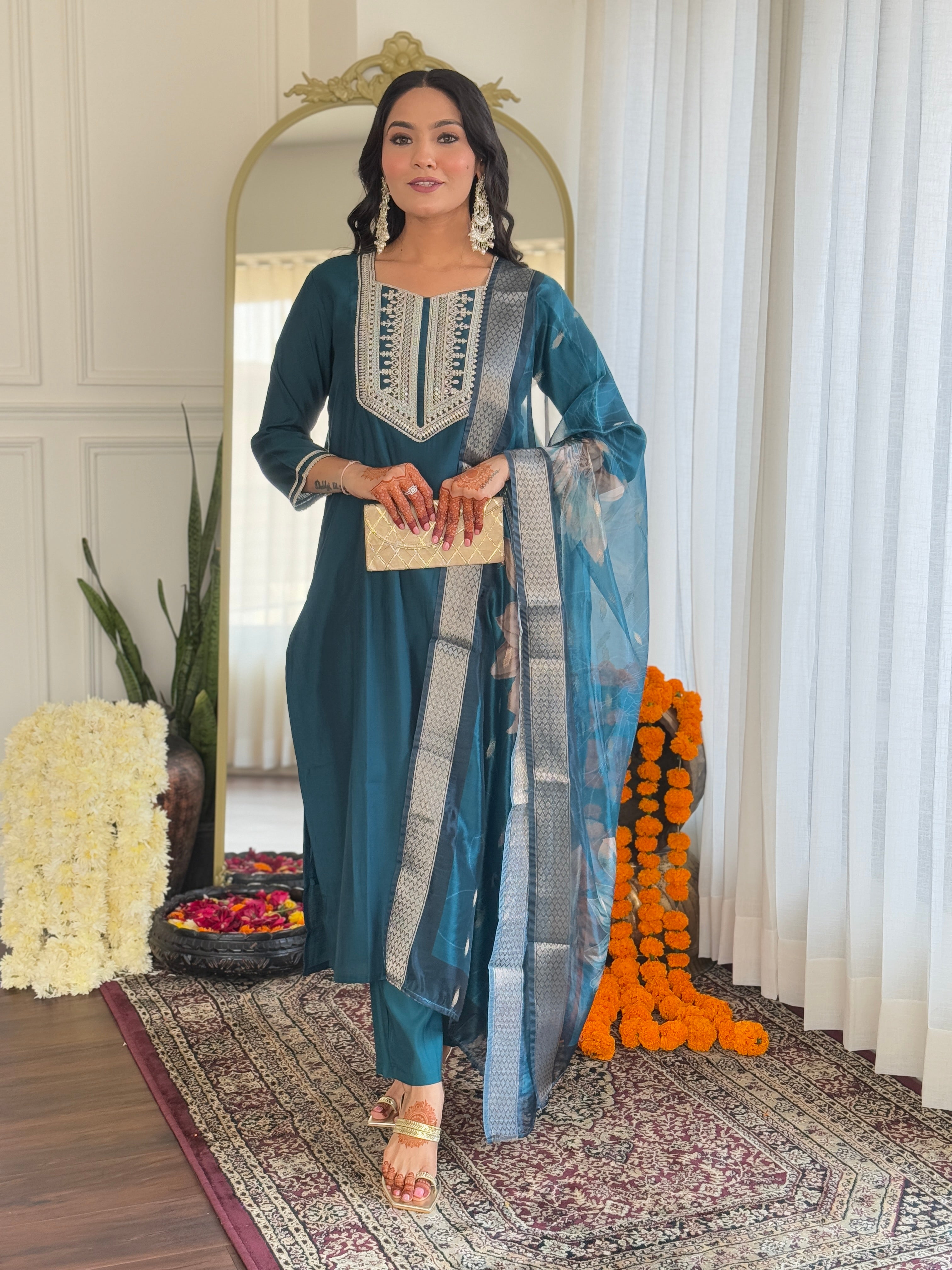 Fashionable woman smiling in a teal kurti set with intricate embroidery and a patterned dupatta, showcasing the outfit's front.