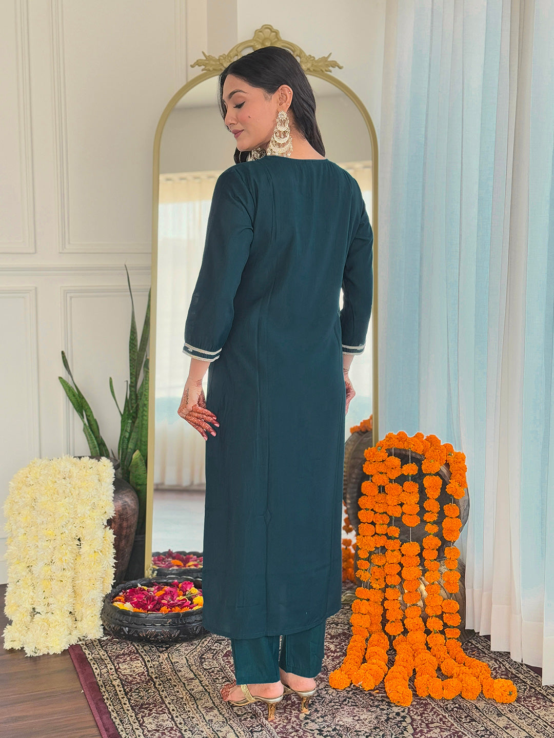 Back view of the woman wearing the teal BSY viscose kurti set, highlighting the plain back and simple design, with henna on her hand.