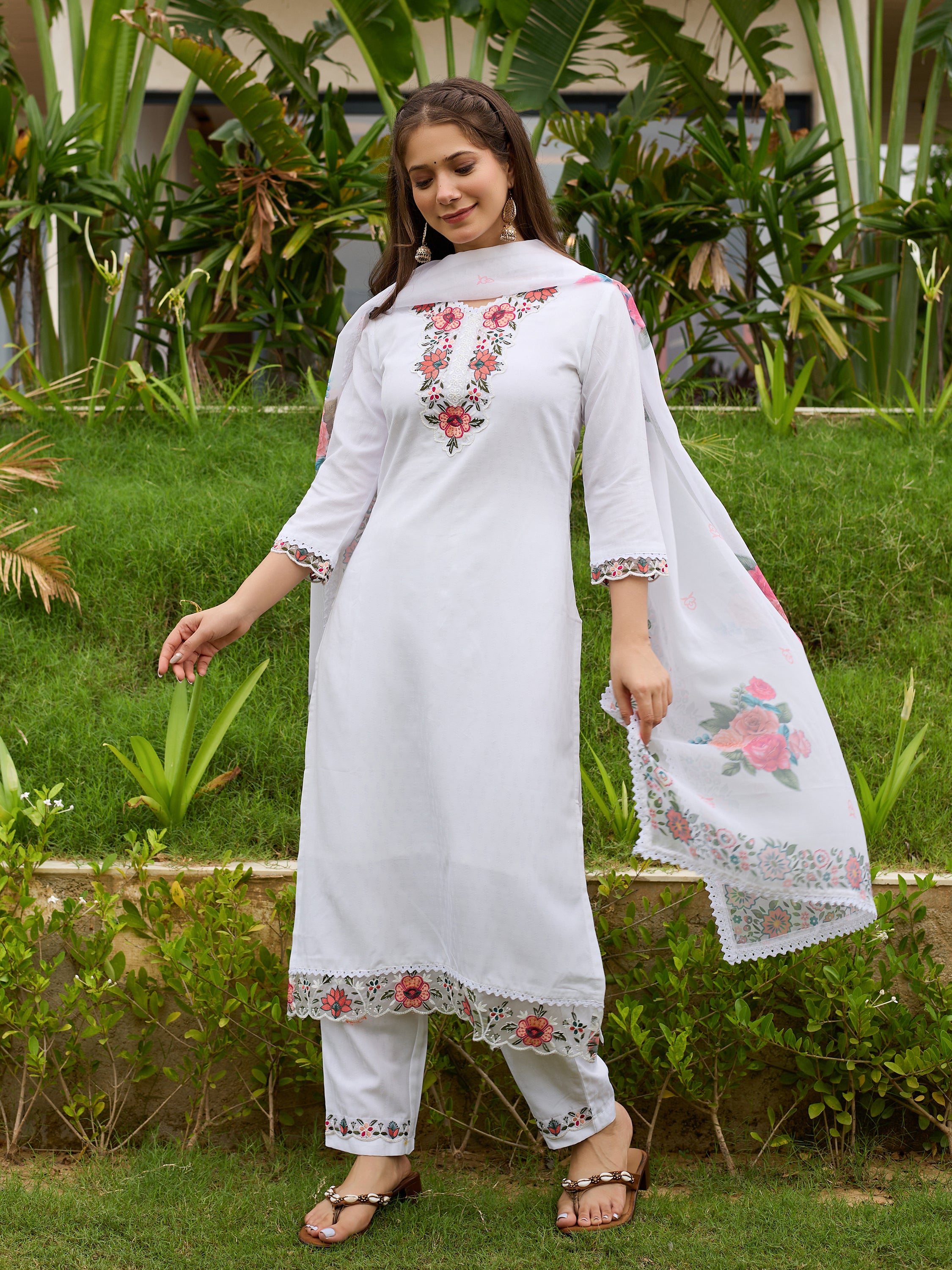 Model posing gracefully, showcasing the flow of the white kurta set with embroidery and floral printed dupatta.