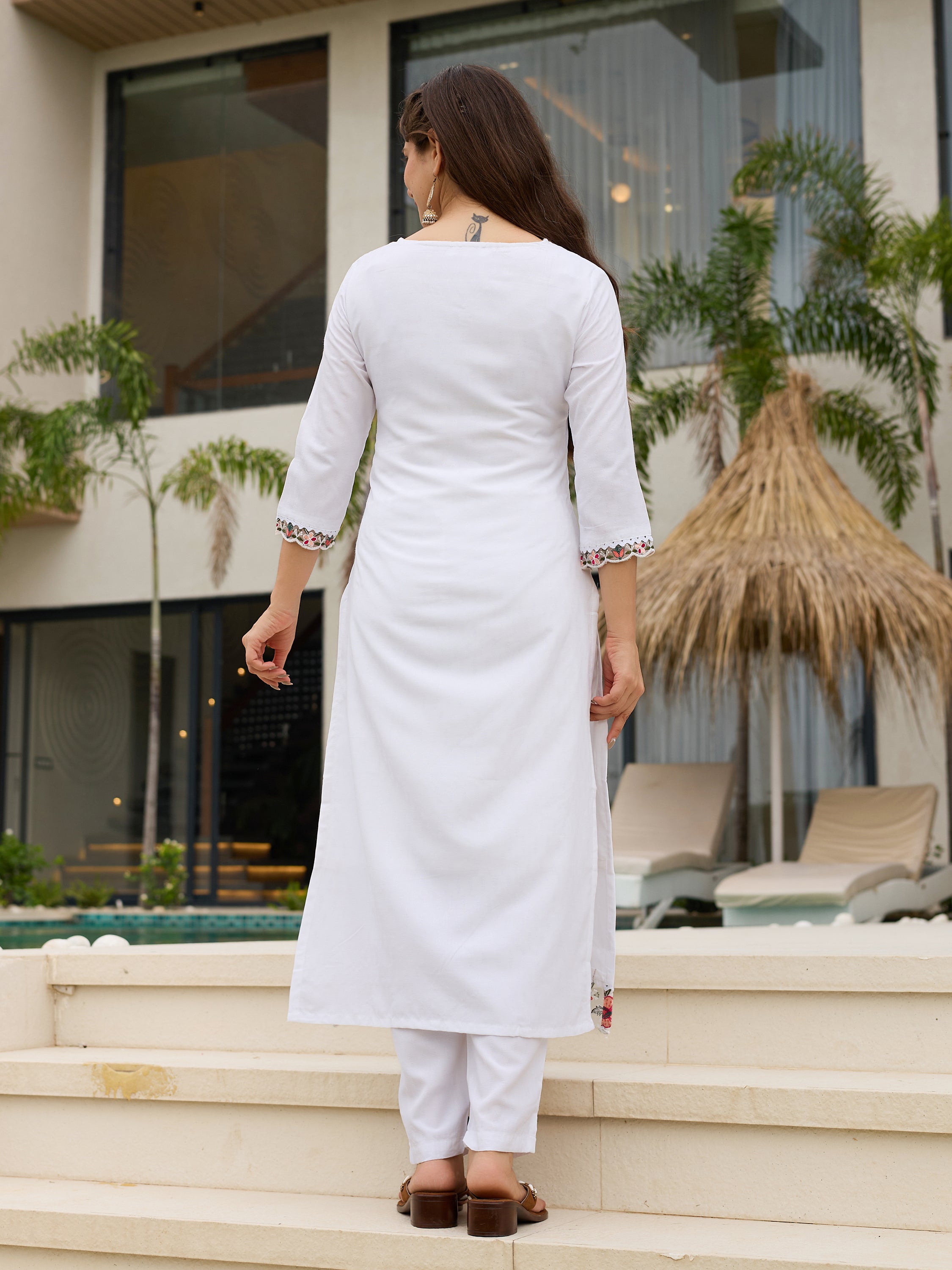 Back view of the TRENDBUY white embroidered kurti set, showing the clean design and length, model standing on steps.