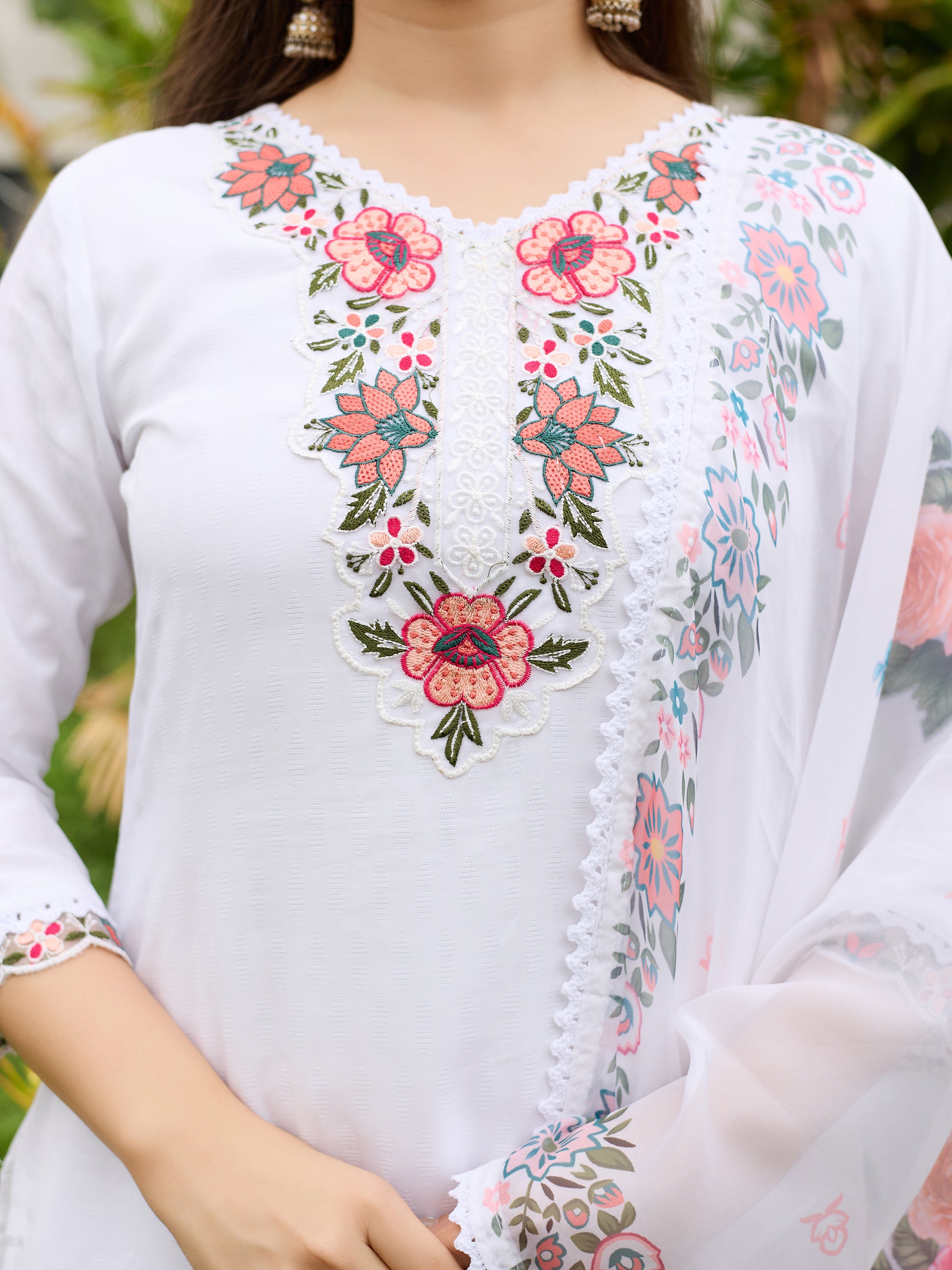 Close-up of the intricate embroidery on the neckline and border of the TRENDBUY white kurti and dupatta, featuring floral patterns.
