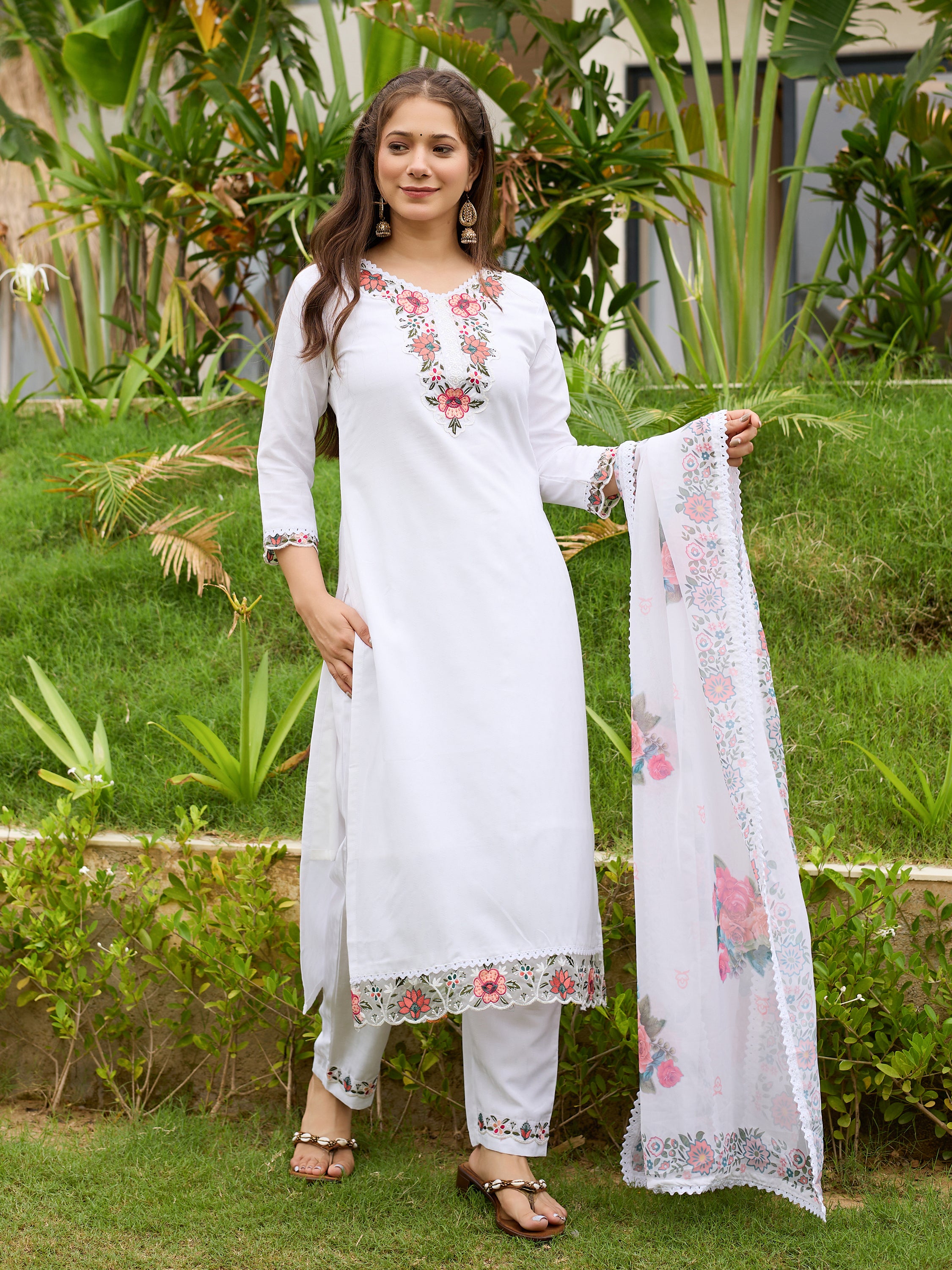 TRENDBUY model posing with the white embroidered taby dupatta held gracefully, showcasing the full kurti set in a garden setting.