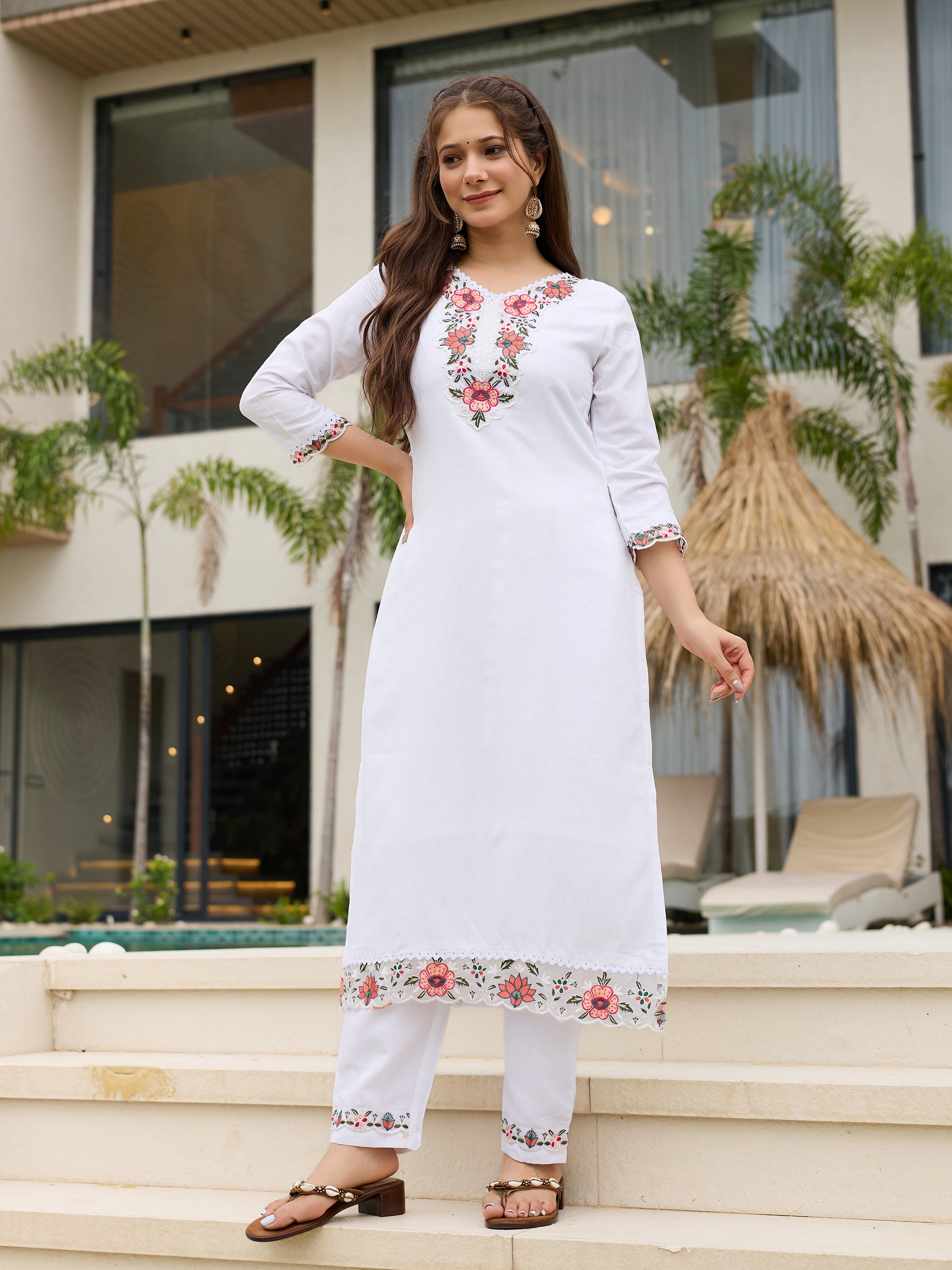 TRENDBUY model looking away, highlighting the side profile and the flow of the white embroidered kurti and matching pant set.