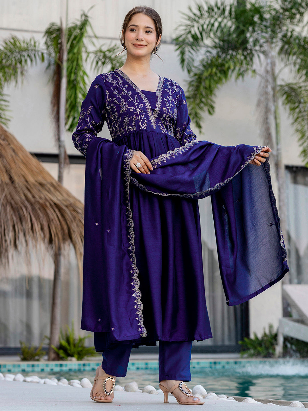 Woman gracefully holding embroidered blue dupatta, showcasing its scalloped border details and subtle embellishments