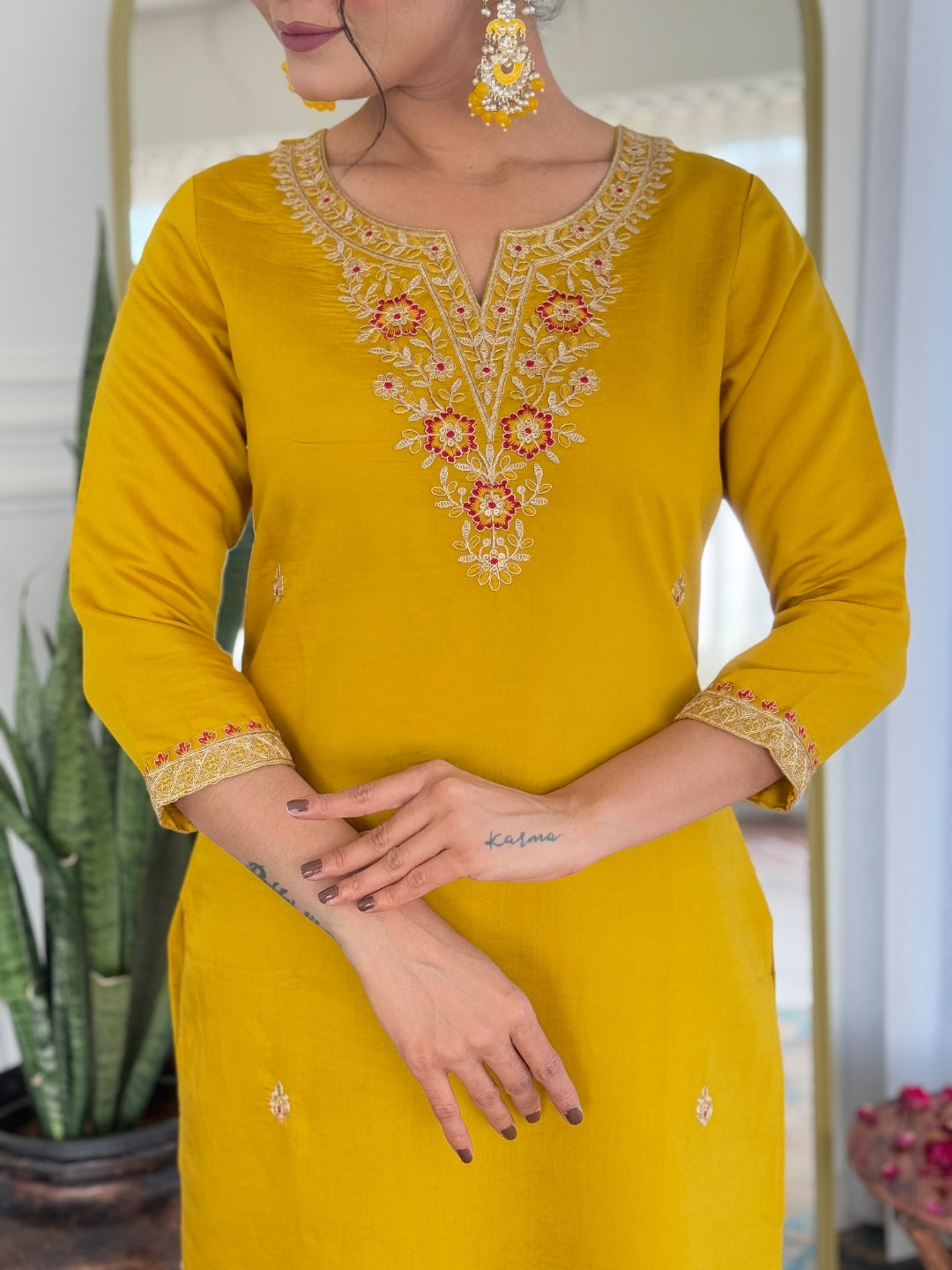 Close-up of the intricate embroidery on the V-neckline and border on the sleeves of the mustard rayon kurti
