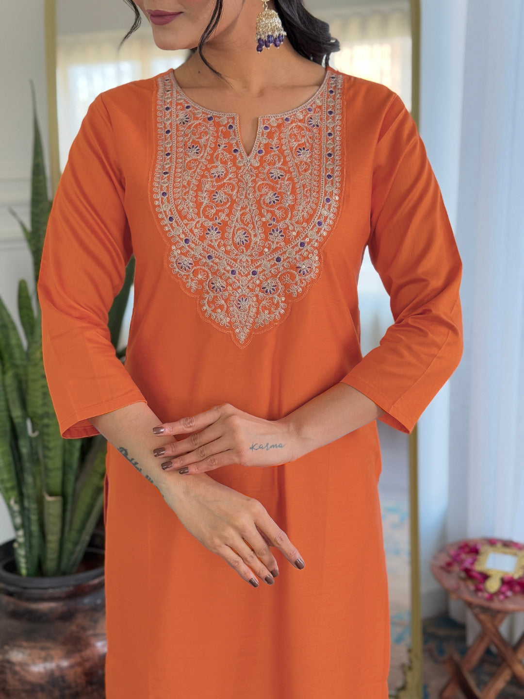 Close-up of the intricate embroidery on the neckline of the orange rayon kurti, showcasing craftsmanship.