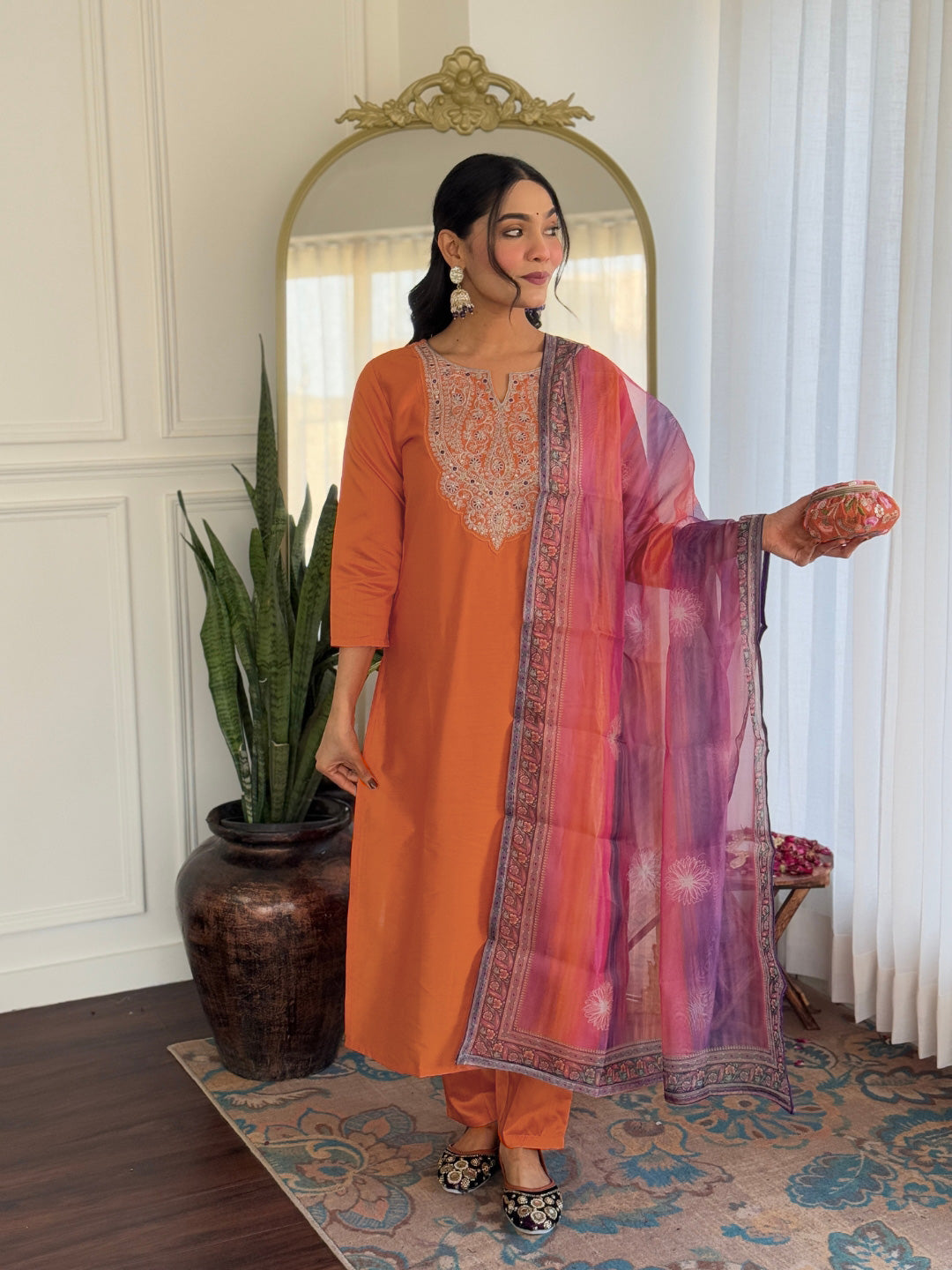 Stylish side profile of a woman wearing the orange embroidered kurti set, demonstrating its comfortable fit.