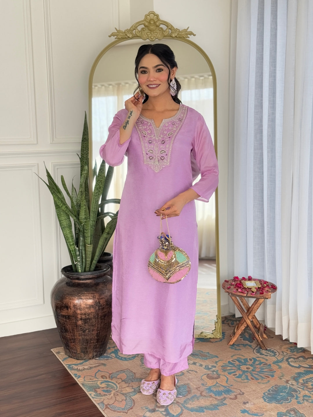 Smiling model adjusting earrings, featuring the complete lavender ethnic wear outfit by TRENDBUY.