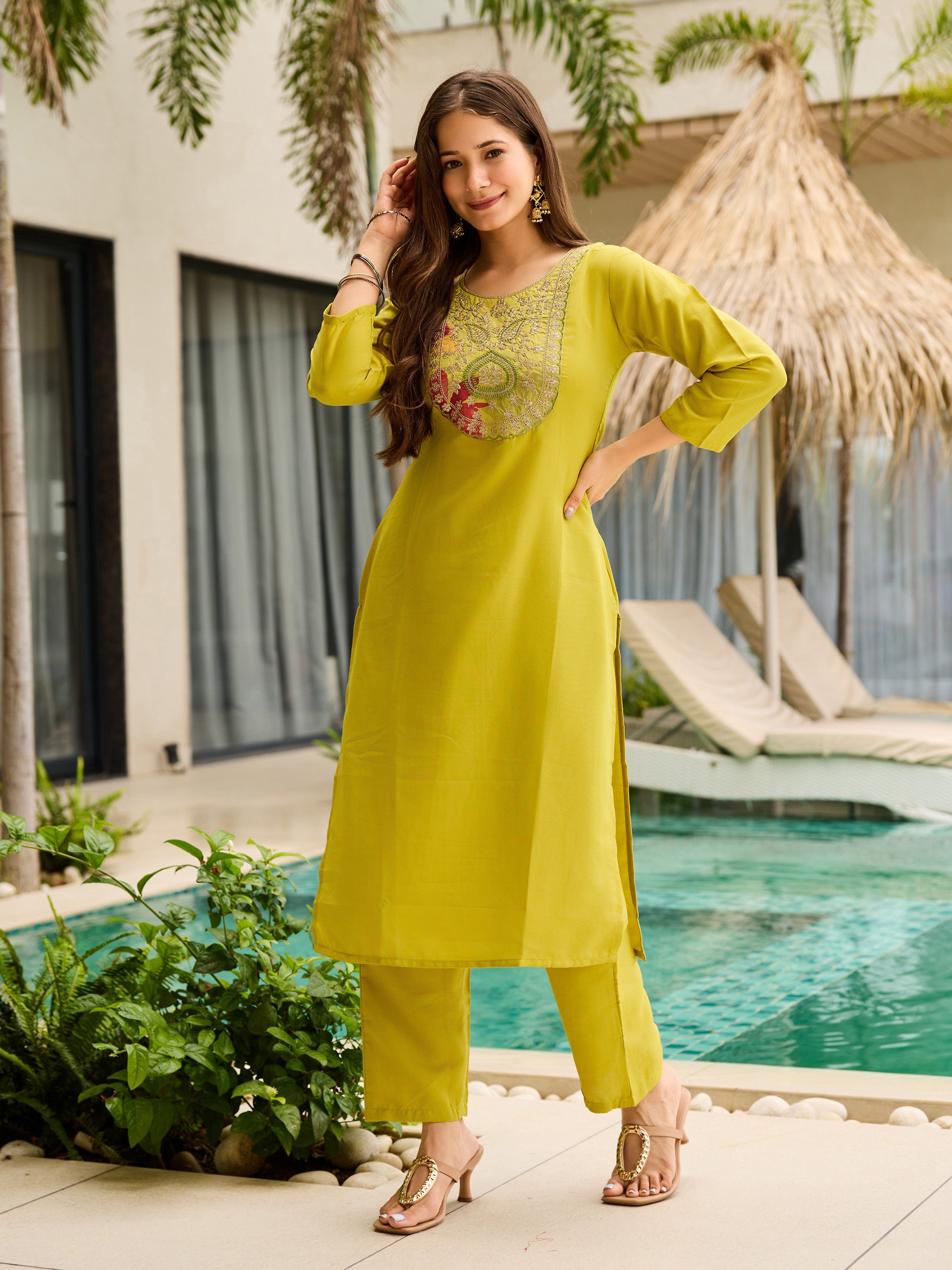Confident woman striking a pose in the trendy Liril Green Rayon Kurta set with its beautifully embroidered neckline and simple silhouette.