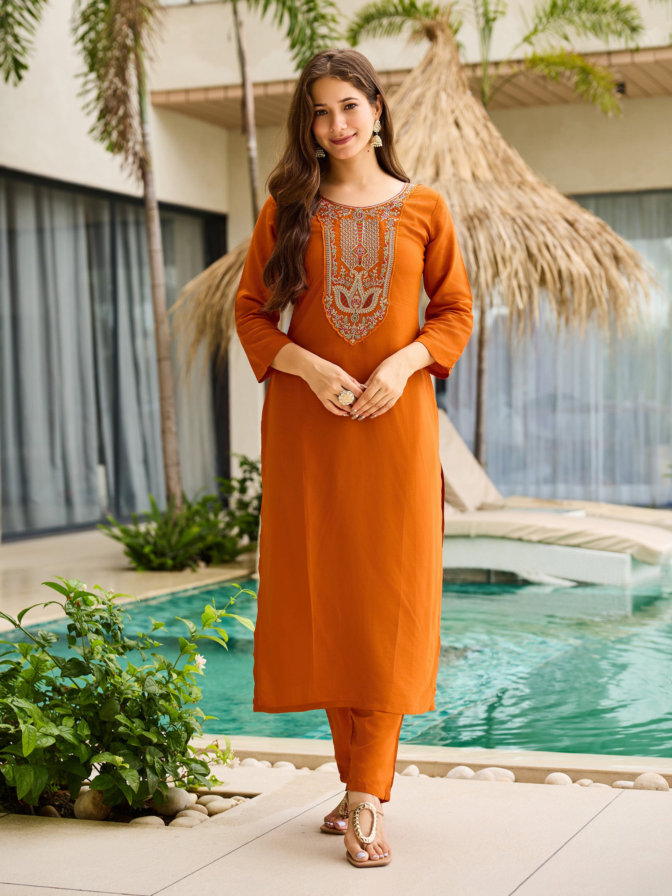 Model elegantly posing in a rust orange rayon kurta pant set, showcasing the full outfit's simplicity and style