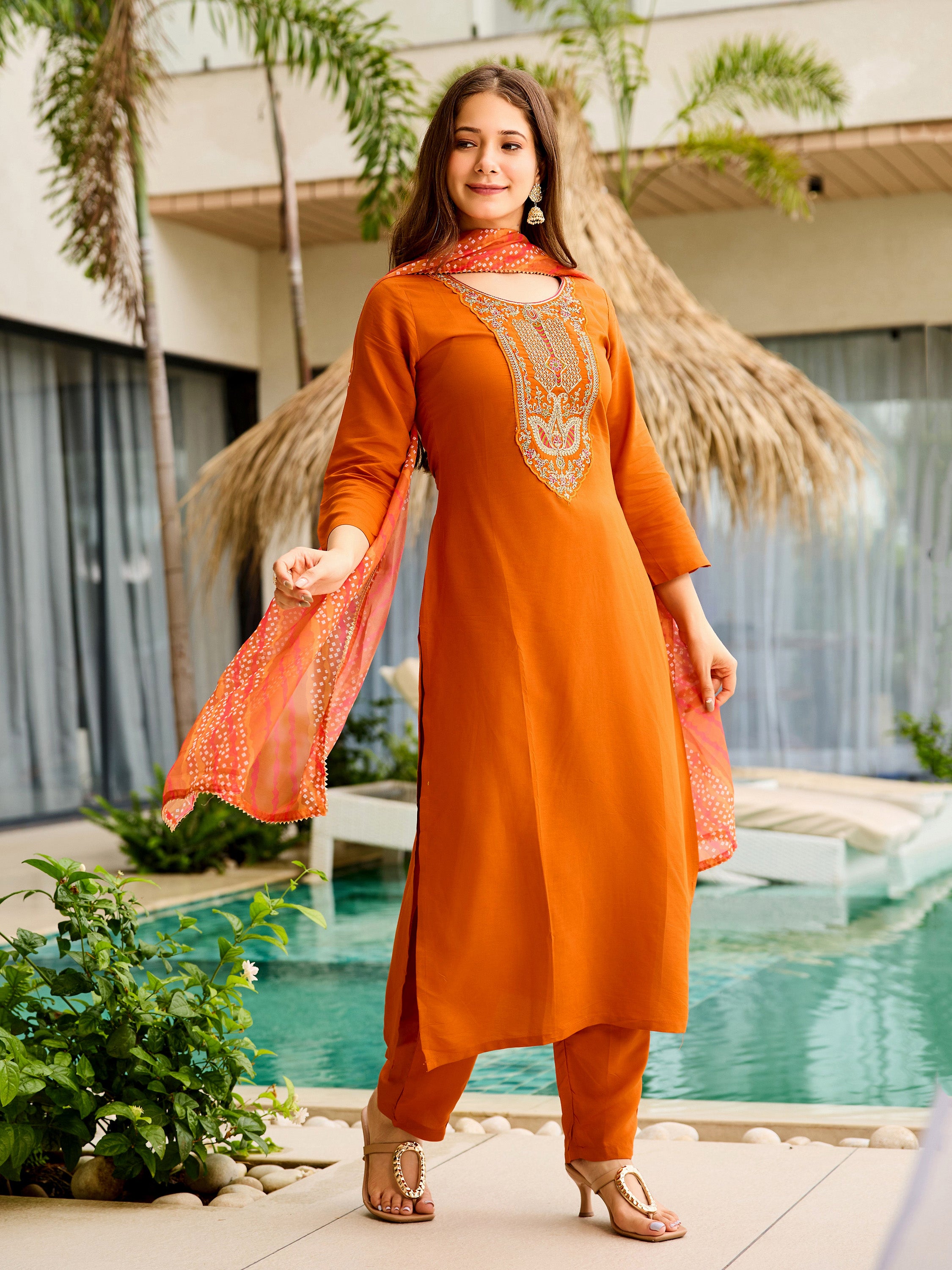 Model posing gracefully with the rust orange rayon embroidered kurta and elegantly draped patterned Taby dupatta