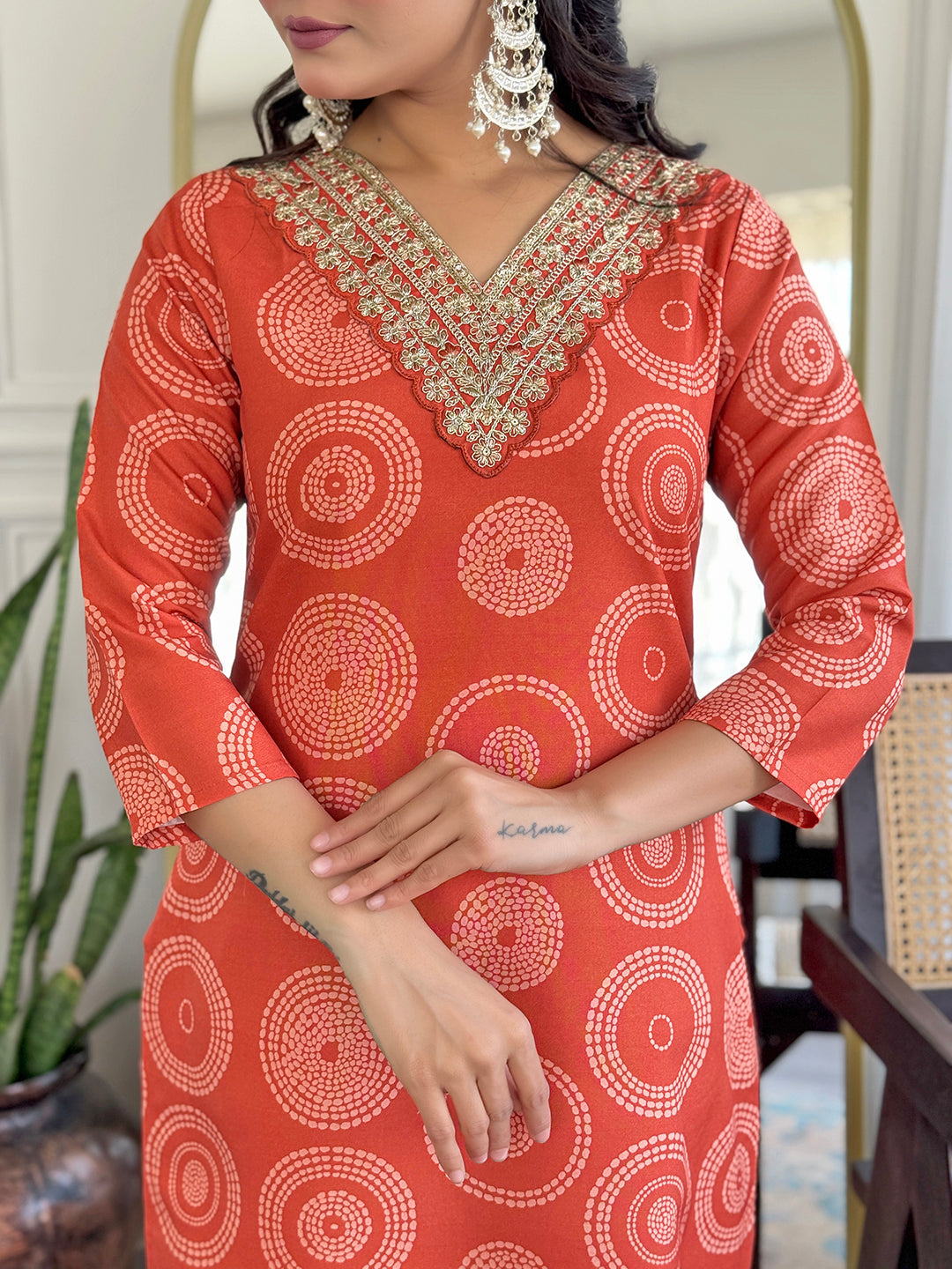 Close-up of the D732 orange kurti's V-neckline, featuring intricate golden embroidery detail.