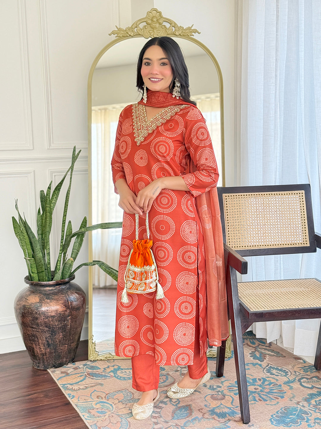 Smiling TRENDBUY model holding a matching potli bag while wearing the D732 orange geometric print kurti pant dupatta set.