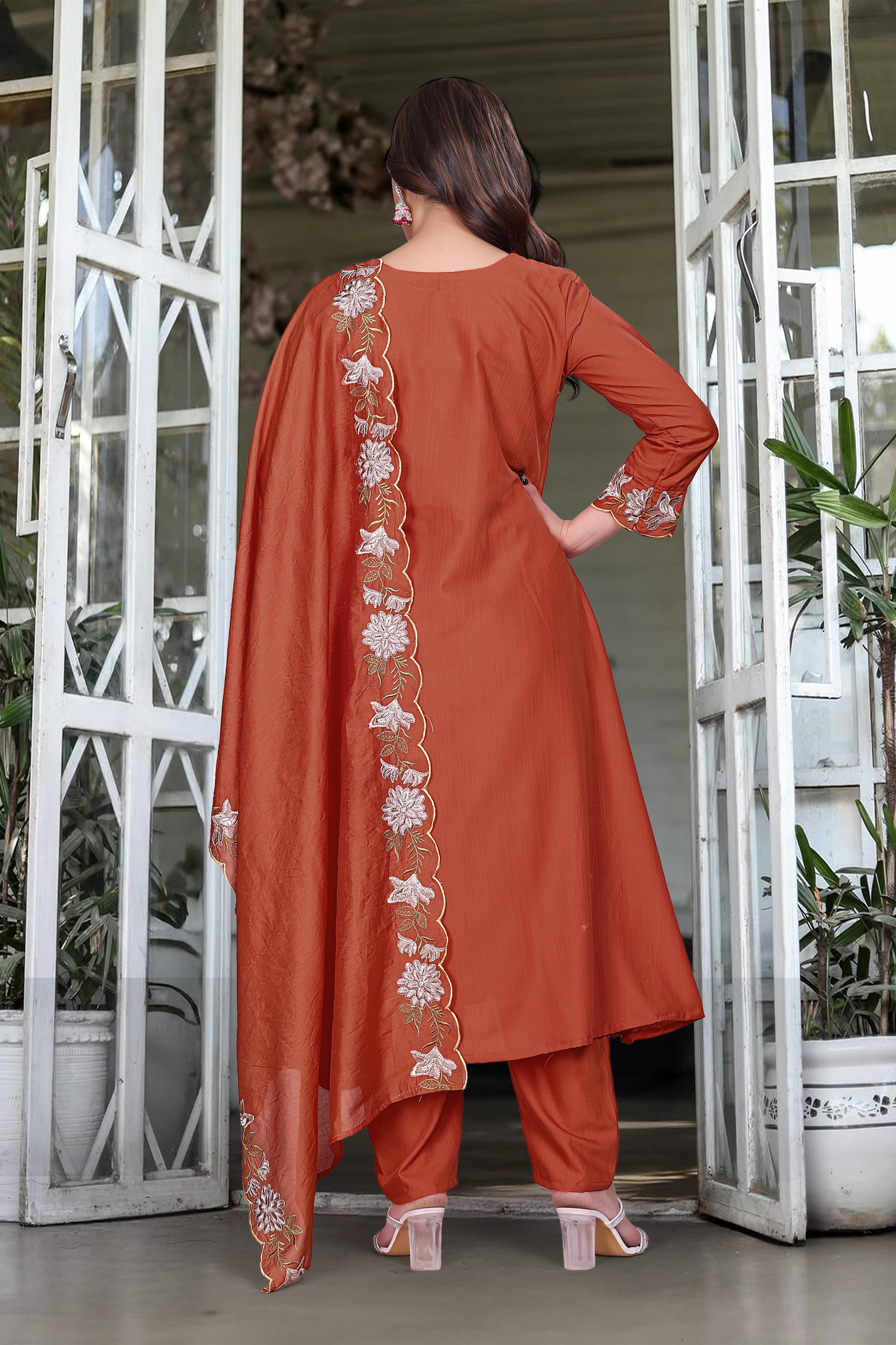 Back view of model in orange rayon slub kurti set, displaying embroidered border on the chanderi dupatta draped over one shoulder.