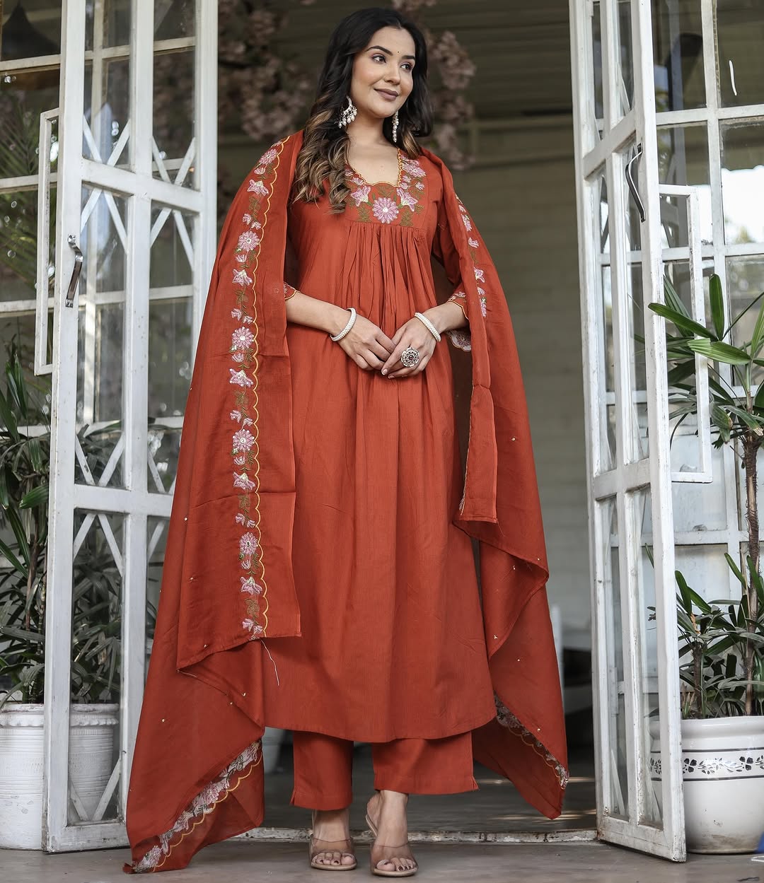 Model posing with orange rayon slub kurti set, dupatta draped elegantly over shoulders, showcasing full outfit.