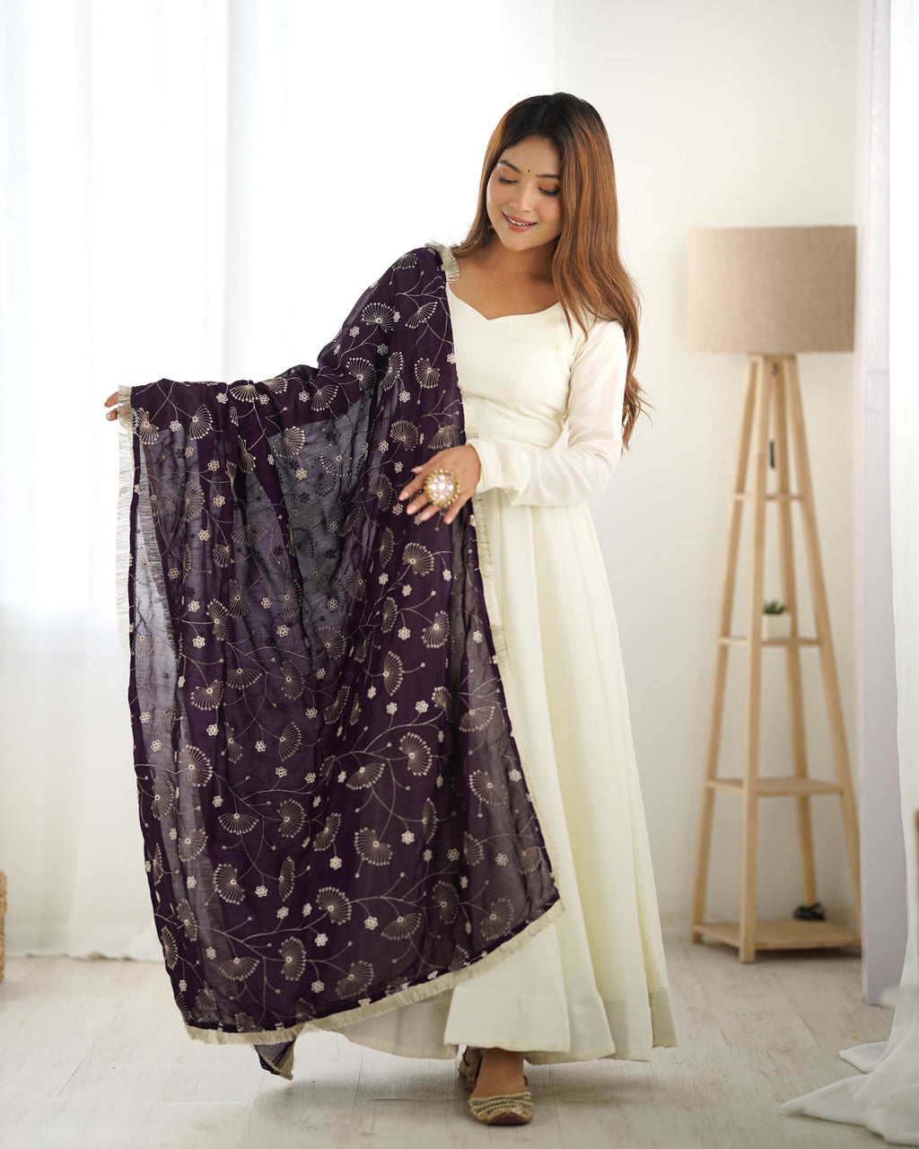 Elegant off-white Anarkali gown with a vibrant wine dupatta, gracefully draped on a model.