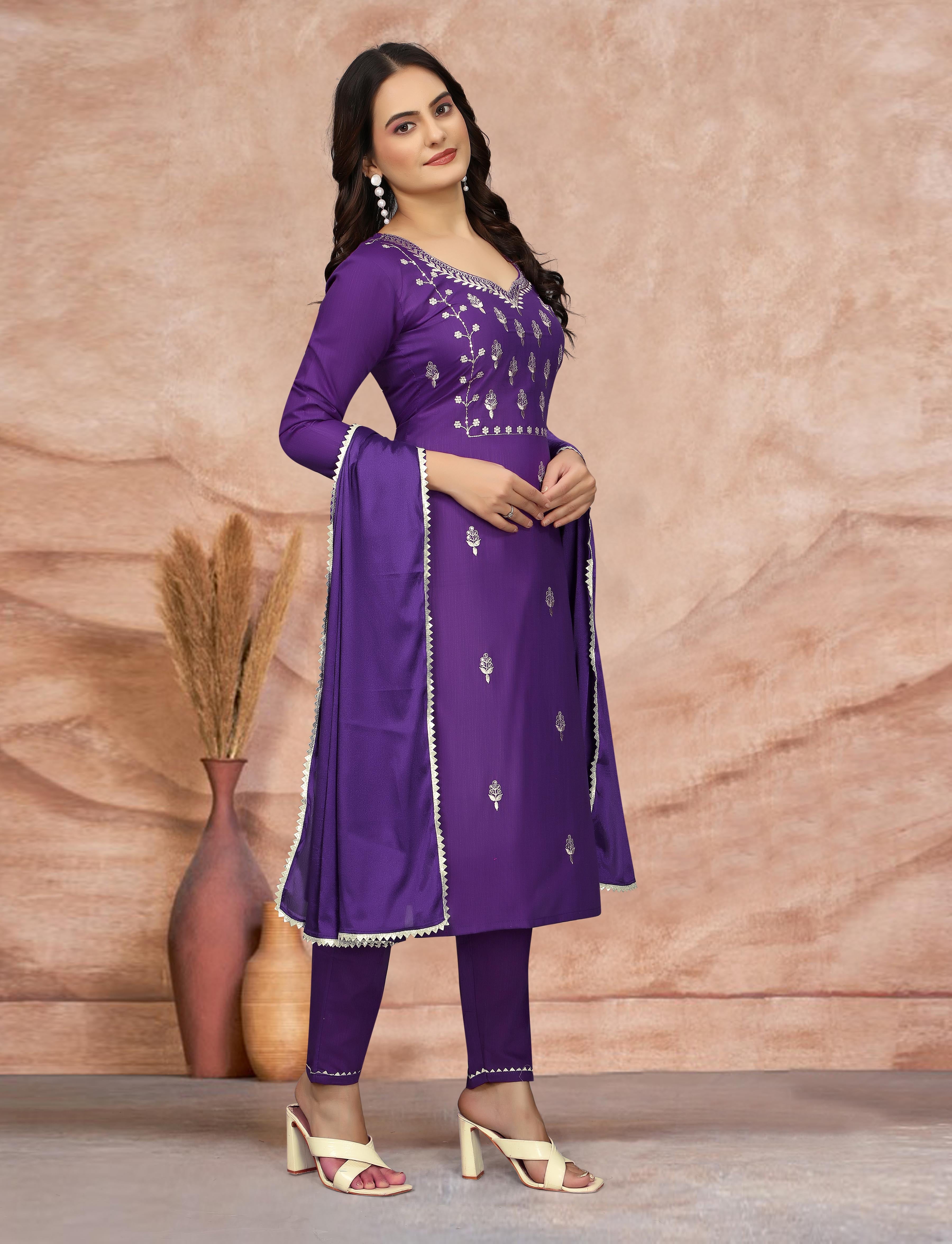 Woman showcasing the purple embroidered kurti set, posing with dupatta, side profile.