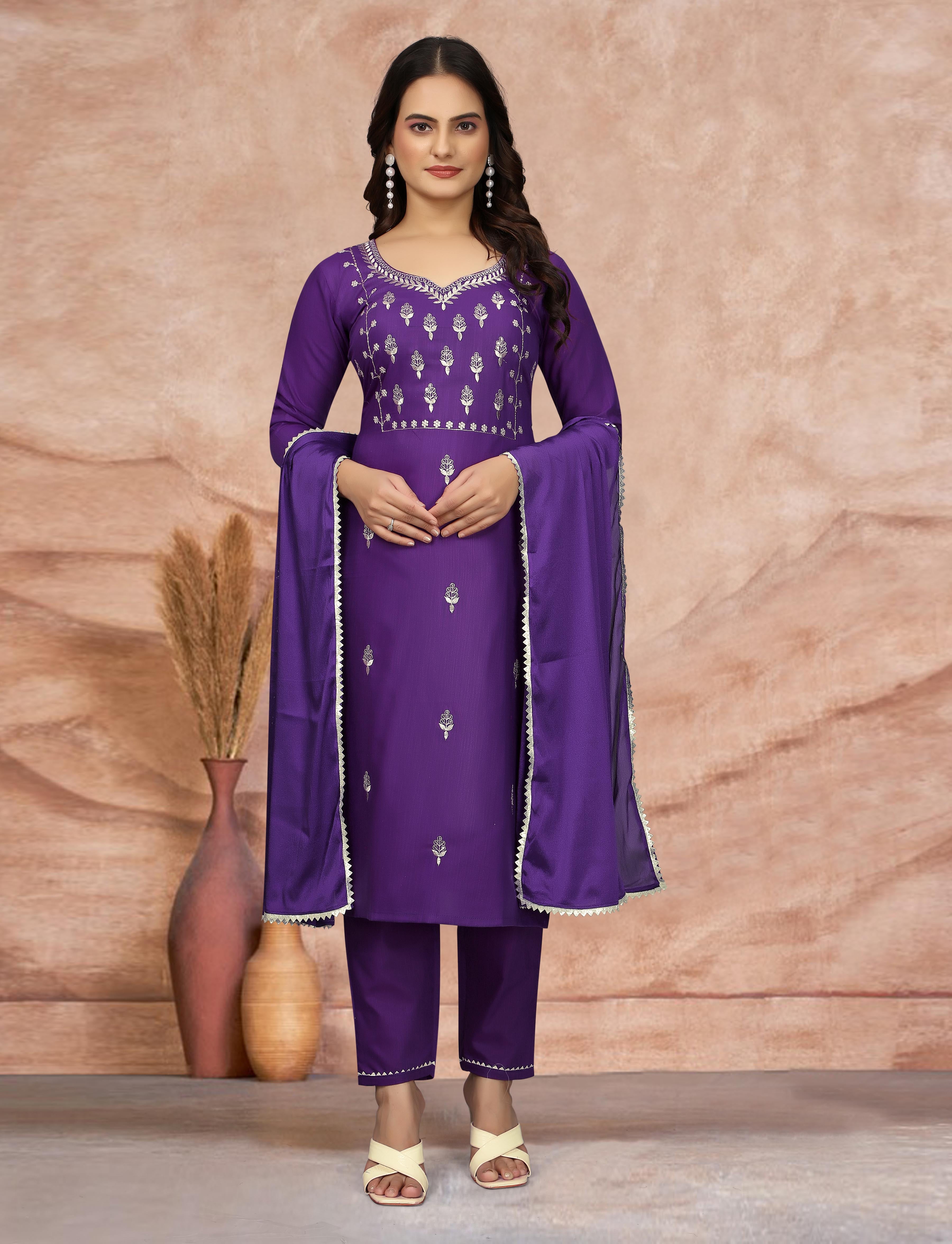 Fashionable woman in purple ethnic kurti set, hands clasped, confident pose.