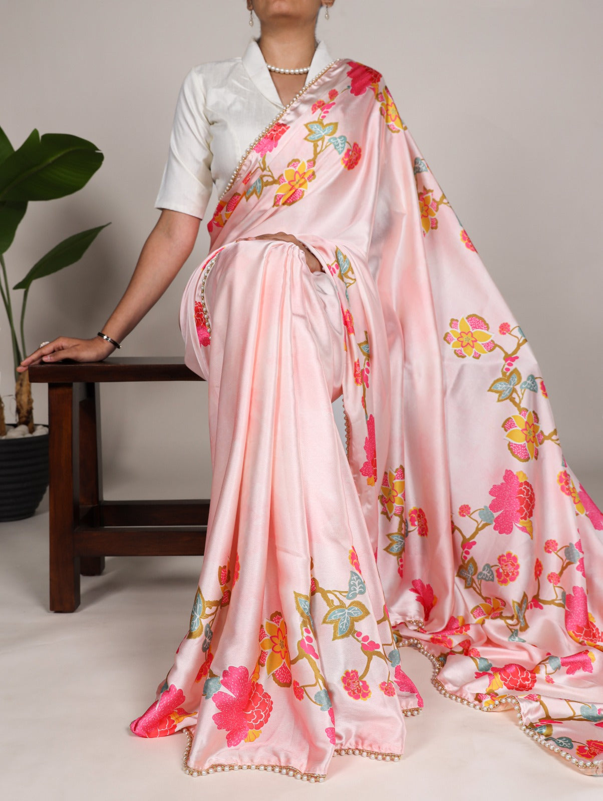 Peach Japan satin silk saree with digital floral print and elegant pearl lace border.