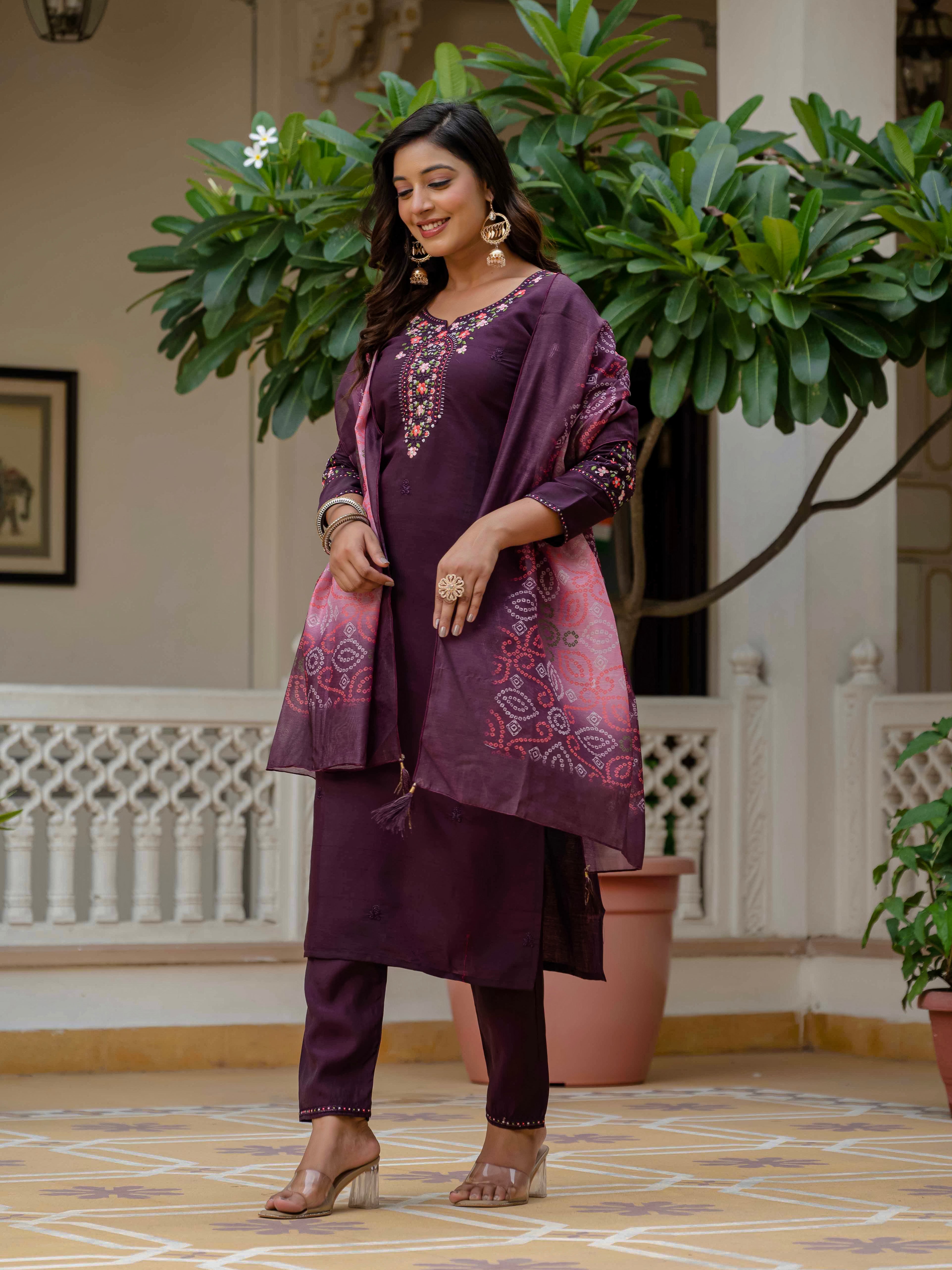 Side profile of a graceful model wearing the purple embroidered kurti set, highlighting the outfit's elegant drape and traditional appeal.