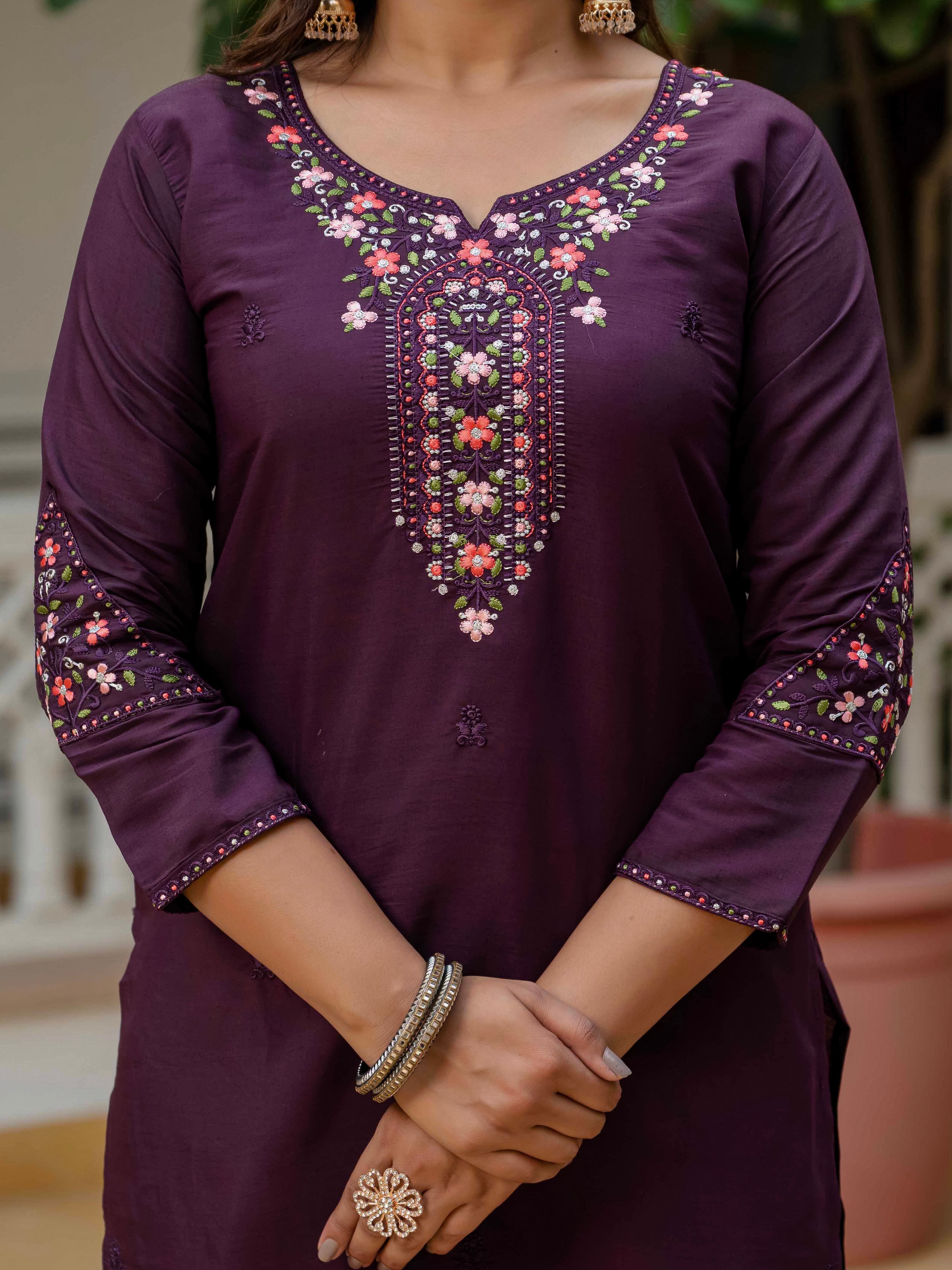 Close-up view of the WF-NYSA kurti's exquisite embroidery on the round neckline and sleeves, against the rich plum fabric.
