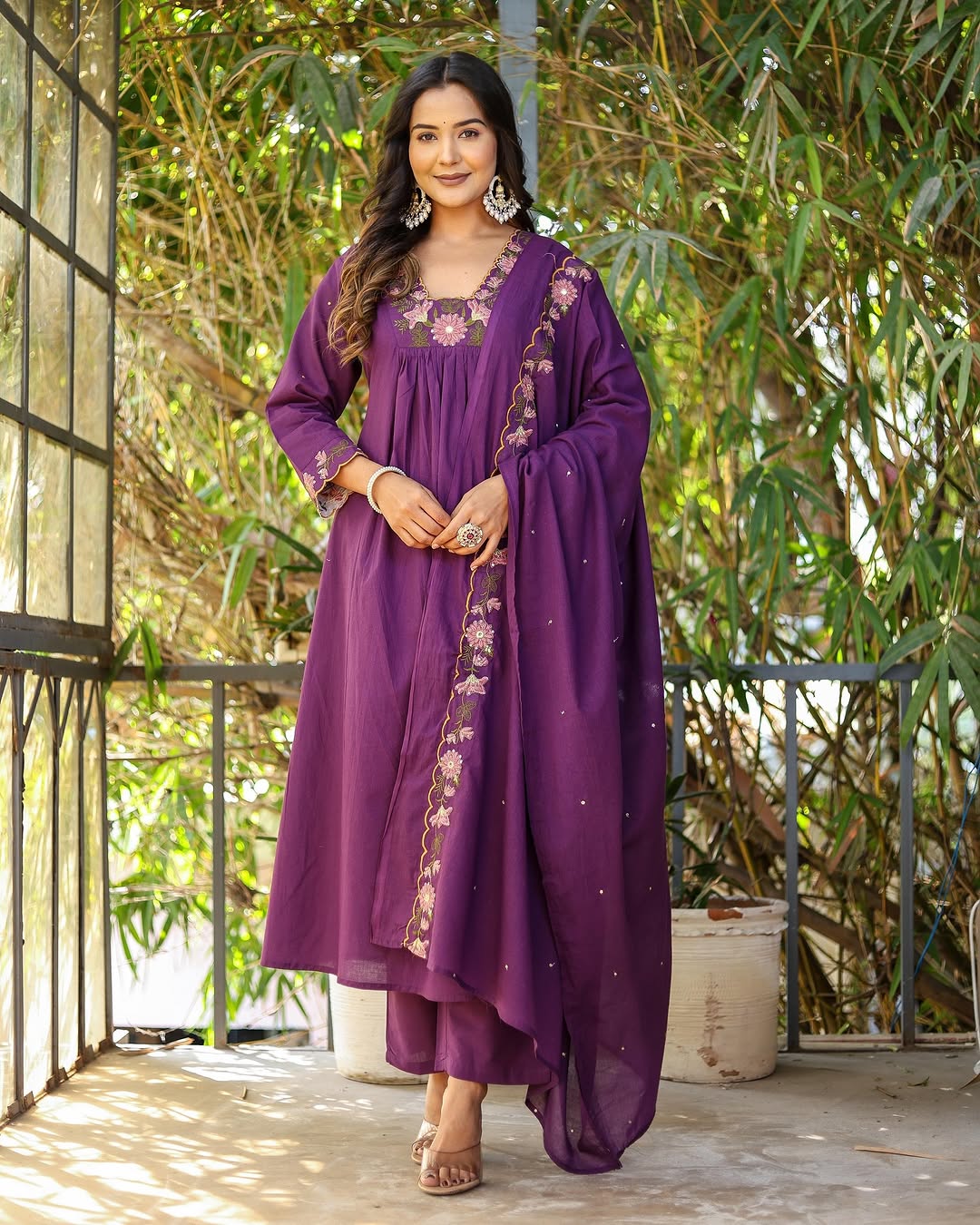 Model smiling, wearing purple rayon slub kurti set with embroidered neckline and chanderi dupatta, standing confidently.