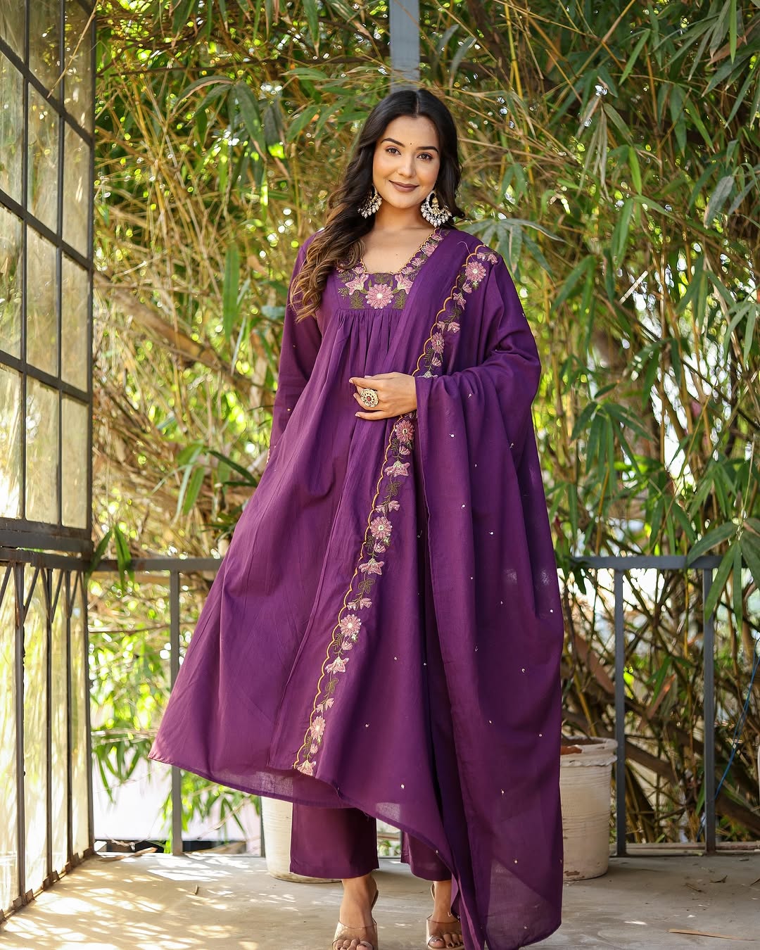 Model posing happily in purple rayon slub kurti set, hands by her side, dupatta draped around her.