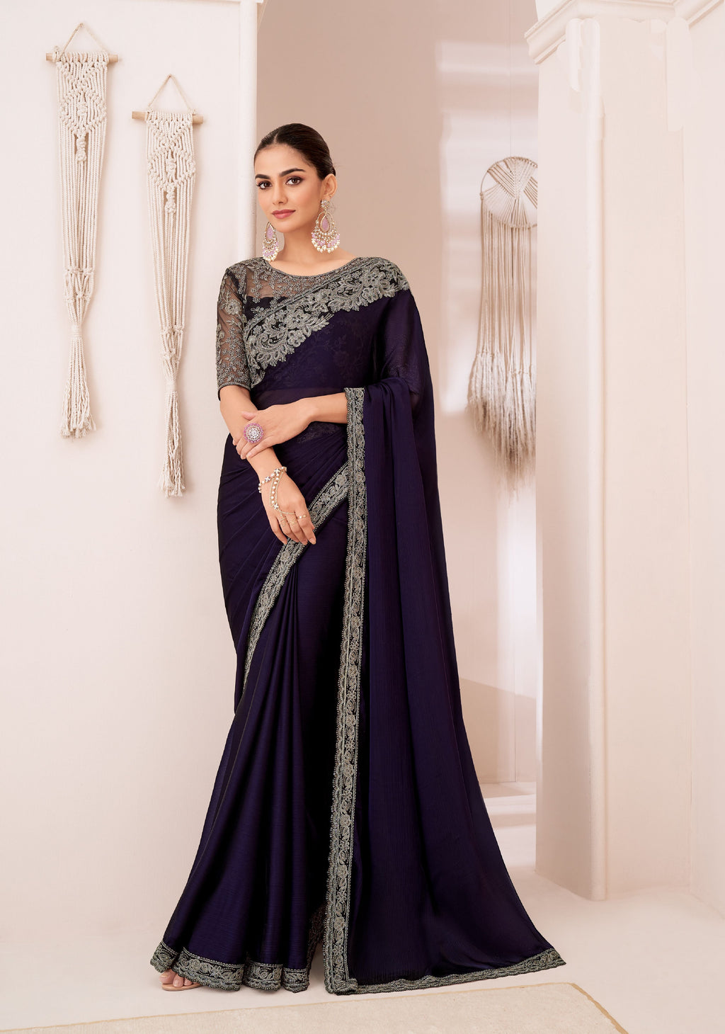 Woman modeling elegant navy georgette chiffon saree, perfect for party wear.