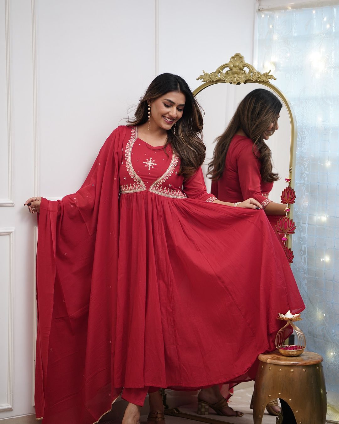 Woman in a red embroidered Muslin Cotton kurta set, gracefully demonstrating the wide flare of the kurta's skirt.