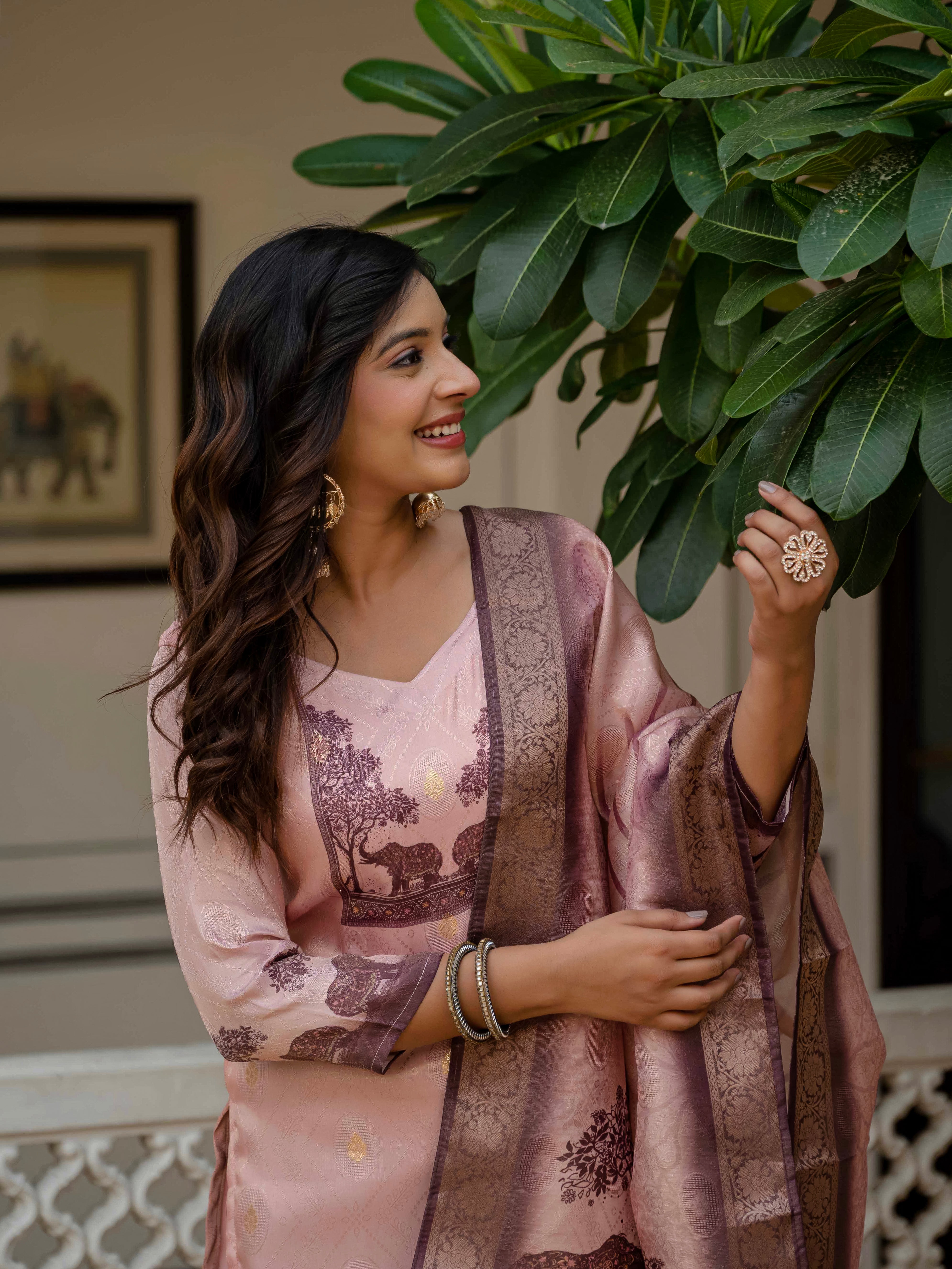 Woman in Royal Pink kurta set looking upwards, admiring a tree, showing the outfit's natural elegance.