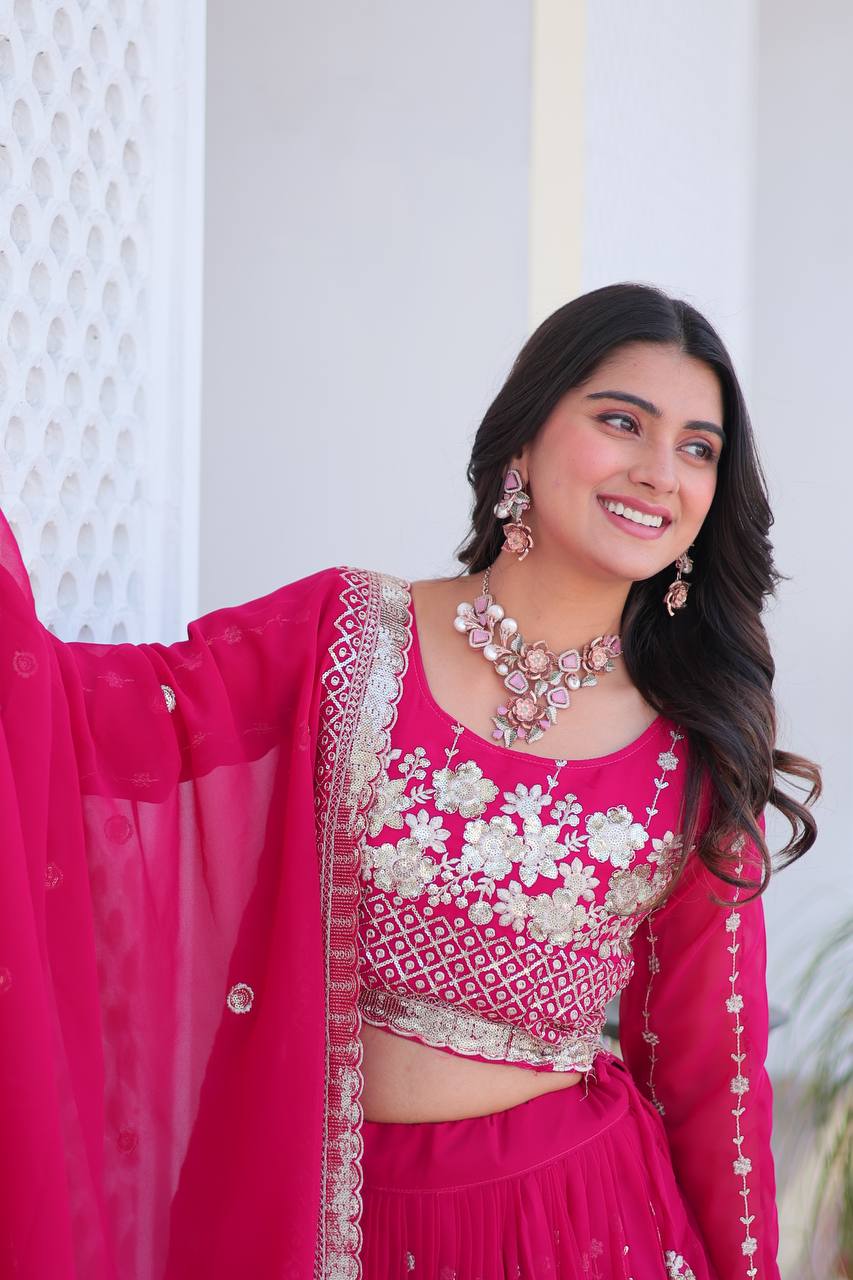 Close-up of intricate gold sequence embroidery on heavy pink georgette fabric.