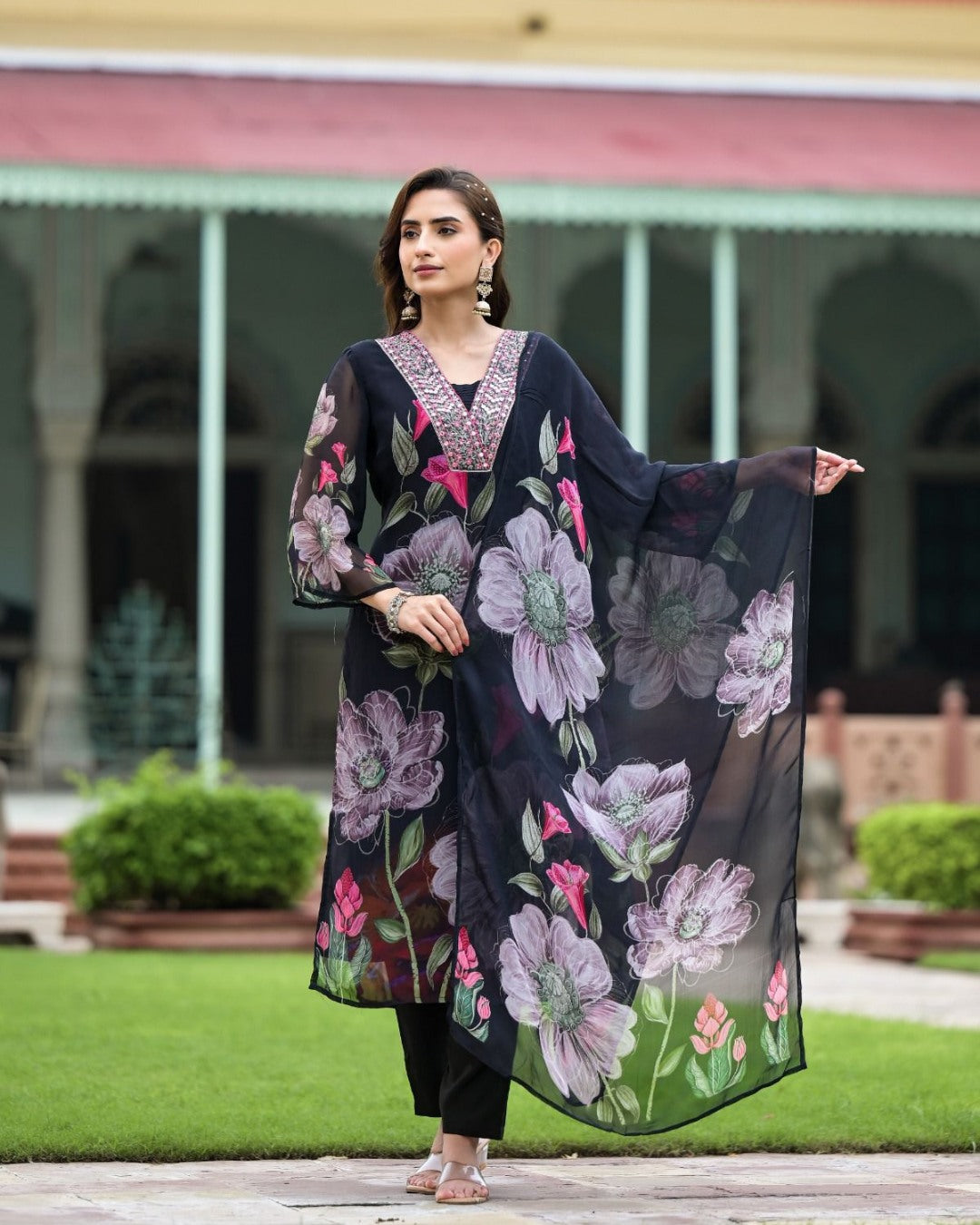 Model gracefully posing in the TRENDBUY Sonika black Georgette kurta set with flowing floral dupatta.