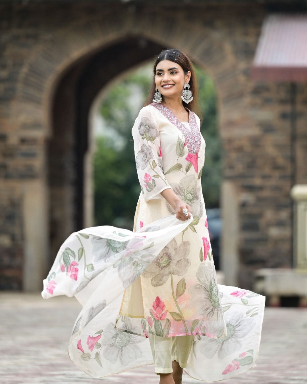 Woman twirling dupatta, showcasing floral print on white Georgette kurta set from TRENDBUY.