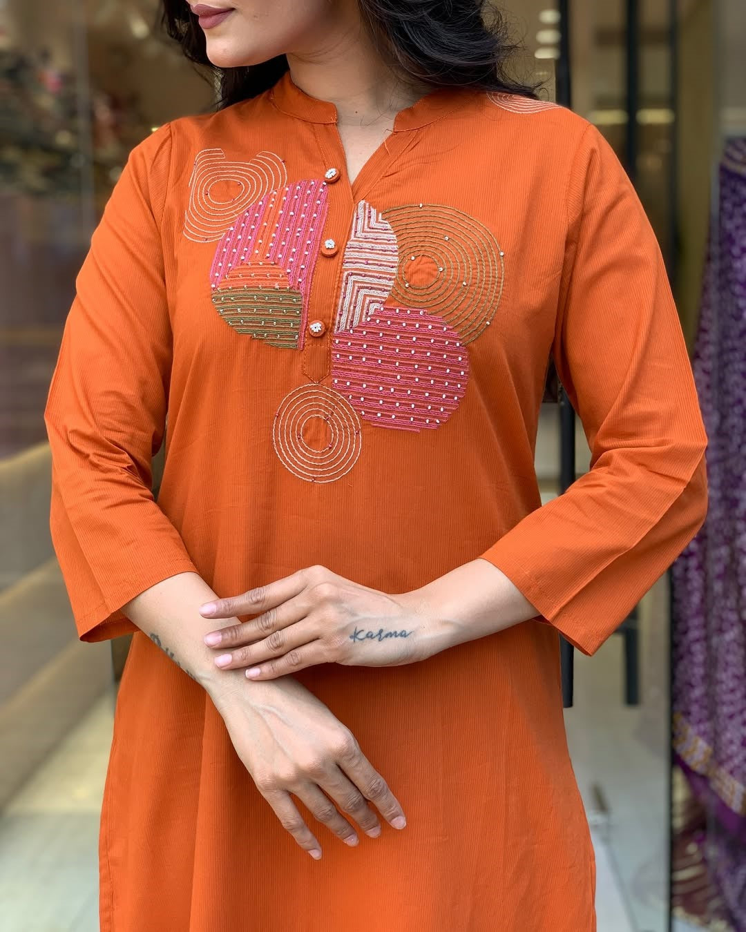 Close-up of the exquisite circular embroidery work on the TRENDBUY orange rayon slub kurti