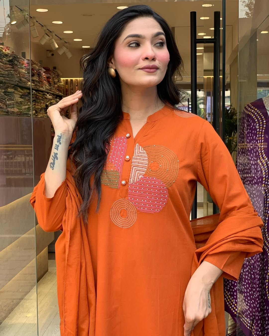 Detailed shot of the embroidered neckline and pearl buttons on the TRENDBUY orange kurti