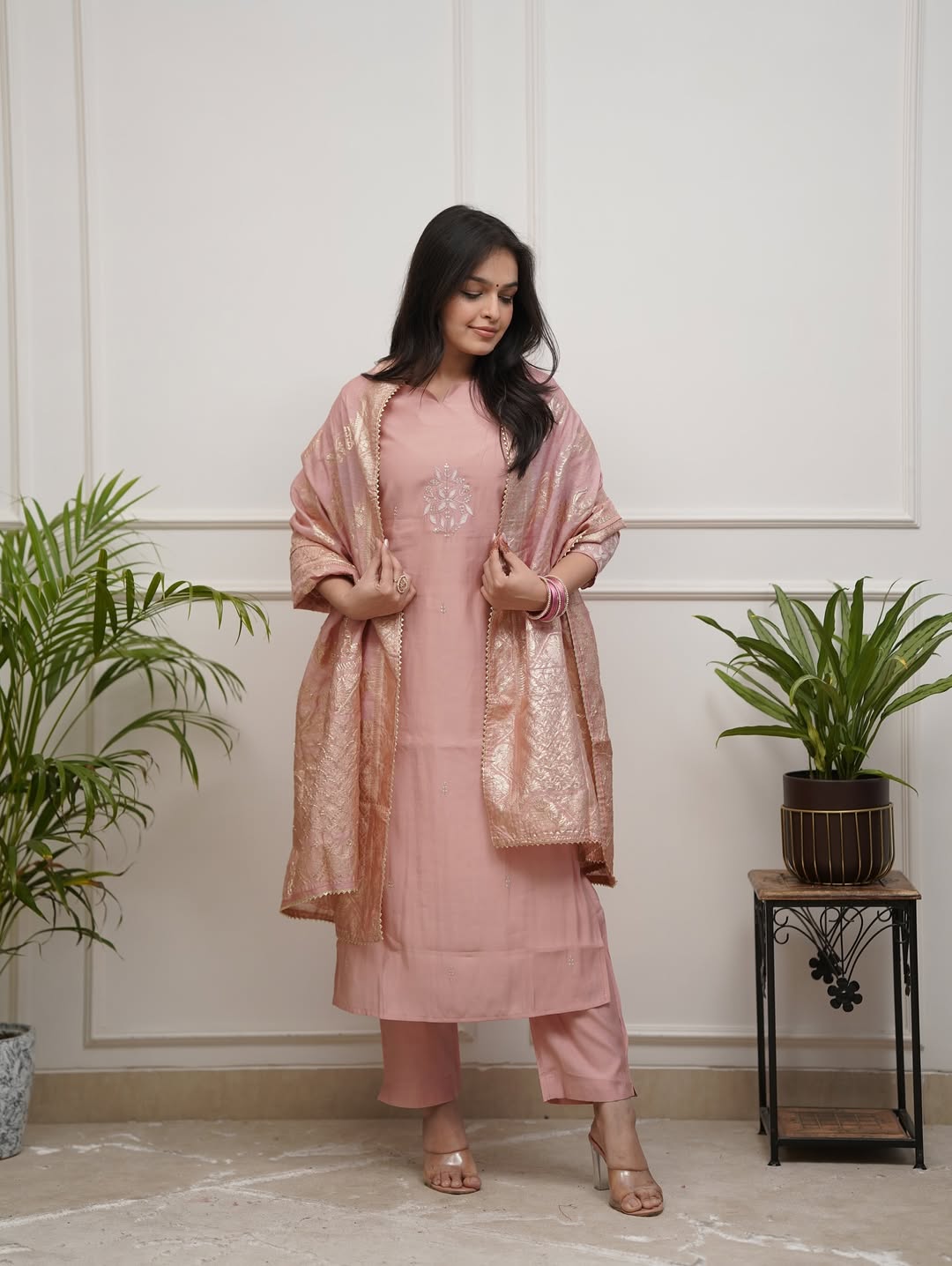 Model in TRENDBUY ST-SWATI peach kurti set, looking down, adjusting the gracefully draped cotton jacquard dupatta, highlighting the ensemble's flow.