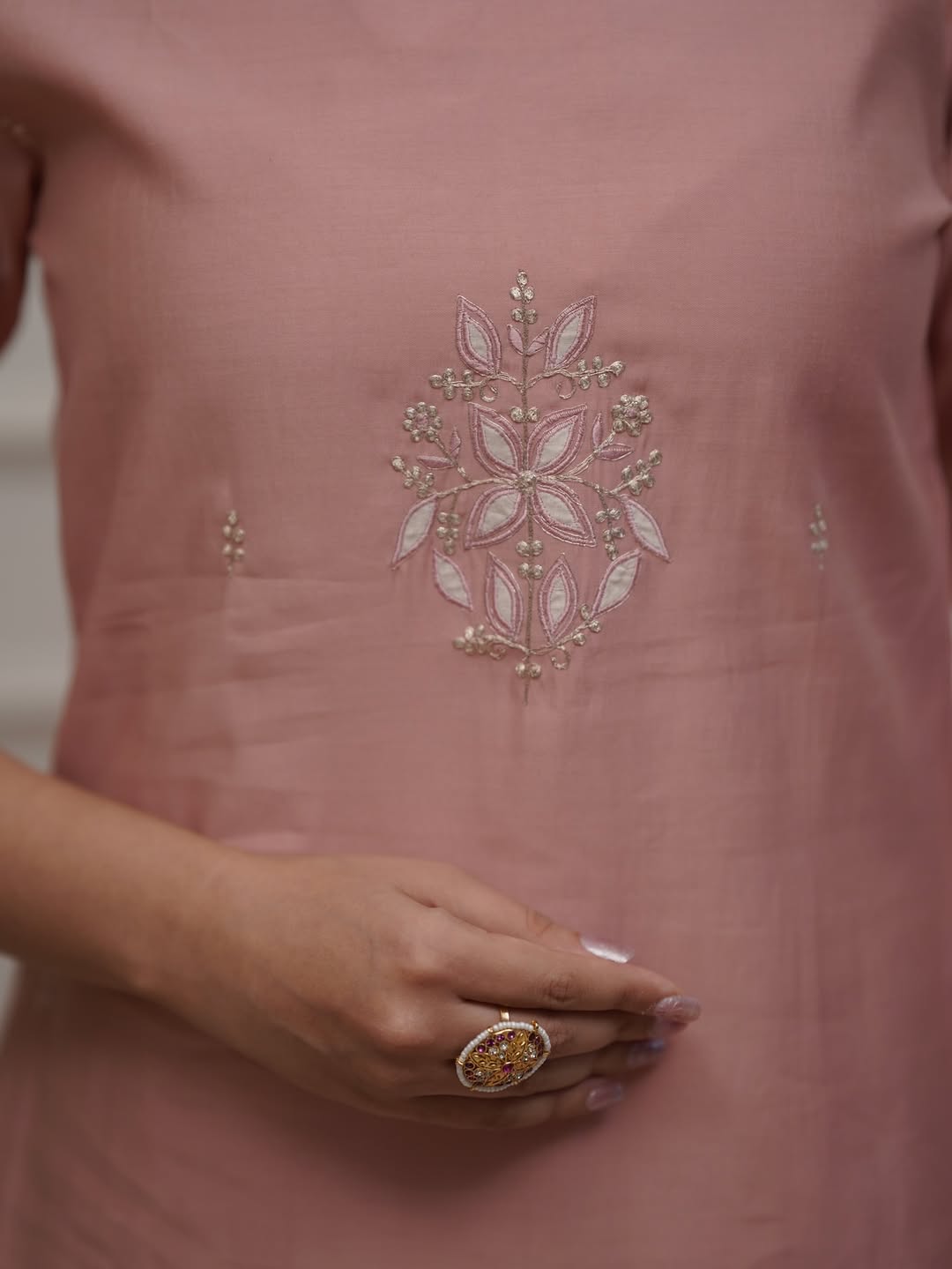 Detailed close-up of the intricate floral embroidery on the chest of the TRENDBUY ST-SWATI peach PV Chanderi kurti.