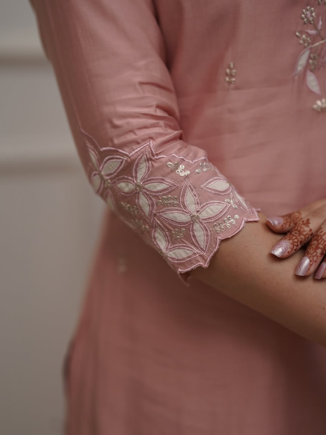 Close-up shot of the beautifully embroidered border on the sleeve of the TRENDBUY ST-SWATI peach PV Chanderi kurti, showing stitch quality.