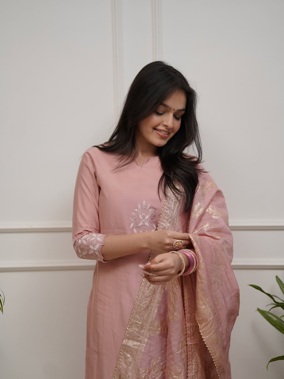 Model in TRENDBUY ST-SWATI peach kurti set, with a gentle smile, adjusting her bangles, drawing attention to the accessories and comfort of the outfit.
